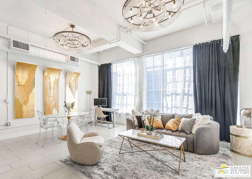 Step into cinematic downtown luxury at 939 S Broadway. This stunning 1-bedroom, 1-bath corner loft glows with light from both the south and west, filling the space with golden afternoon warmth and dramatic sunset views. Framed by ceiling-to-floor plush velvet curtains, the expansive living area is anchored by two grand statement chandeliers, while a three-tier crystal chandelier in the entryway sets an unforgettable tone the moment you arrive. Offered fully furnished, this home is a turnkey designer showcase perfect as a high-performing Airbnb investment or a sophisticated city retreat. Enjoy soaring ceilings, polished concrete floors, and timeless industrial character complemented by resort-style amenities including a rooftop pool and spa, fitness center, and 24-hour security. While the building itself does not include on-site parking, secure parking options are conveniently located directly across the street, making city living both luxurious and effortless. All just steps from DTLA's finest dining, shopping, and entertainment along the vibrant Broadway corridor.
