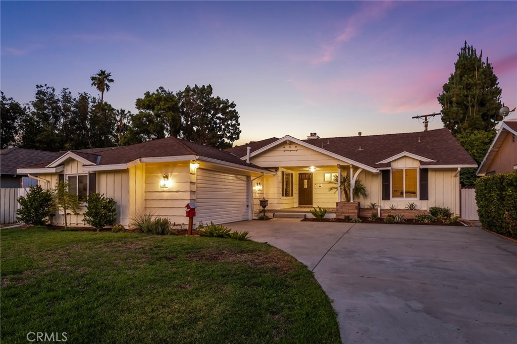 Welcome to 9150 Sophia Avenue, a classic North Hills ranch home offering a perfect blend of comfort and enduring charm. Tucked away on a quiet cul-de-sac, this 3-bedroom, 2-bath home immediately feels like a private retreat on its generous lot. Inside, original hardwood floors bring a timeless warmth to the space, while large windows fill the living room with soft, natural light. A classic brick fireplace anchors the room, creating an inviting focal point for gatherings. The floor plan flows beautifully from the living area to a cheerful eat-in kitchen and a separate formal dining room for any occasion. The layout includes a spacious primary bedroom with an en-suite bath, plus two versatile secondary bedrooms ready for guests or a home office. The backyard is a true extension of the home—a wonderful outdoor living space. The large covered patio is perfect for al fresco dining, overlooking a spacious lawn with mature landscaping and endless possibilities for a garden, pool, or ADU. With a two-car garage for convenience and a location that makes life seamless, 9150 Sophia Avenue is a home that meets you where you are—and welcomes where you're going.