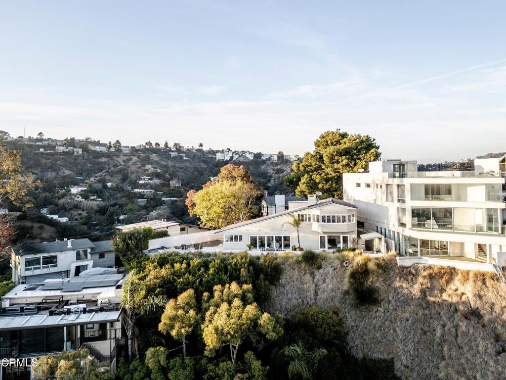 Dramatic architectural home with pool designed by noted architect Barton C. Phelps, FAIA, 1981. Located in historic Laurel Canyon, this unique contemporary was built for award-winning film editor Lynzee Klingman and offers breathtaking, unobstructed views of the ocean, downtown Los Angeles and the surrounding hills. Sited on a wide, flat parcel consisting of 3 lots, the home invites both relaxation and entertainment. As you enter, folding doors of glass merge interior and exterior spaces, extending sight lines and allowing for natural light to flood the interior. The contemporary layout features a cozy living area with fireplace, perfect for intimate gatherings, while the dining area sets the stage for elegant dinner parties. The open gourmet kitchen is equipped with high-end stainless steel appliances and modern designer touches, catering to culinary enthusiasts. Step outside to your private oasis, complete with a heated pool and spa that overlook the stunning LA Basin, and a wrap-around sundeck, ideal for hosting outdoor dinners under the stars. The great room, kitchen, primary suite, secondary suite, pool, and patio, all enjoy spectacular jetliner views. Highlights: *3 BR, 2.5 BA. *2 BR suites with views. *3rd BR with fireplace currently used as a den/library. *New roof 2024 with warranty. *New universal EV charger; both Tesla and non-Tesla EV capable with built in universal adaptor & 40 amp power level. *Pool equipment recently refurbished + Wifi Controlled. *LPG back-up generator system. *Attached two-car carport that can fit additional cars *Security cameras *Dedicated exterior storage room *Wonderland school district *Renovations in 2004 designed by Janet Olmsted Cross, AIA. With its rare wide lot, pool/spa, stunning views, and easy access to the Sunset Strip and WeHo, 8326 Grand View Drive allows for the best in Southern California living and entertaining.