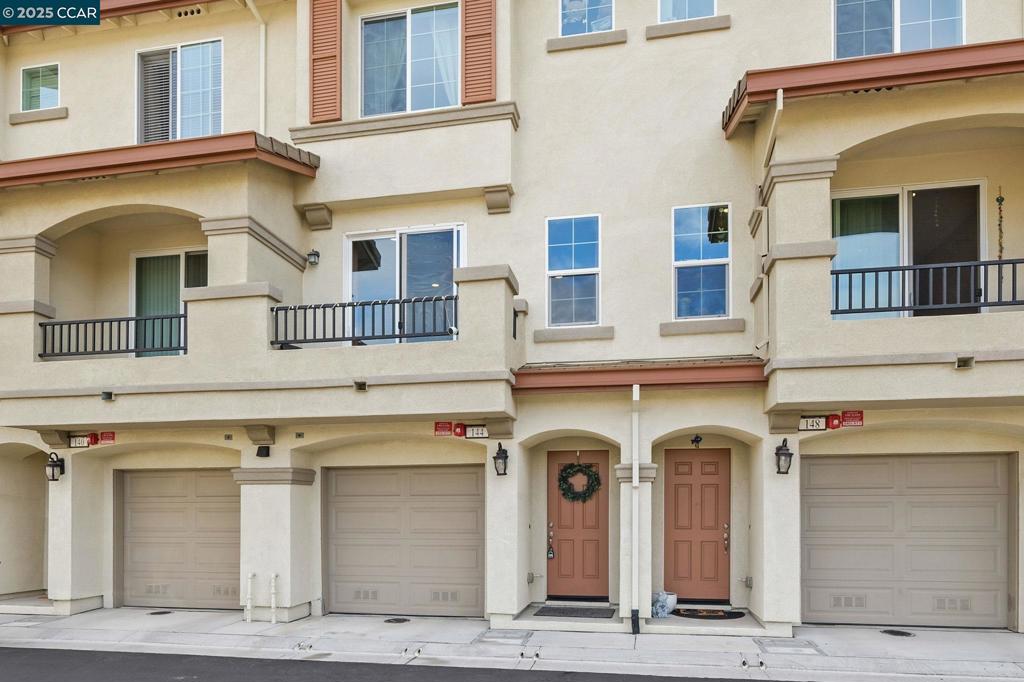 Ideally located near premier shopping, dining, and with convenient freeway access, this recently built townhouse offers modern design, thoughtful functionality, and elevated comfort. The ground level features a two-car tandem finished garage with durable polyurea flooring and ample storage space. Upon entry, a warm and neutral landing sets the tone for the home’s contemporary aesthetic. The main living level is designed for both everyday living and entertaining. The chef’s kitchen showcases a large island with sleek quartz countertops, premium stainless steel appliances, a breakfast bar, and a casual dining area. The adjacent family room is filled with natural light and opens to a balcony with stunning views. Also on this level is a versatile third bedroom, perfect for a home office, guest suite, or flex space. Upstairs, the expansive primary suite serves as a peaceful retreat, offering a spacious layout, en-suite bathroom with dual sinks, tile flooring, and a large walk-in shower—plus sweeping views. A well-appointed guest bedroom provides generous storage and refined designer touches. Additional highlights include in-unit laundry hookups and a charming back patio, enhancing the home’s blend of style and practicality.