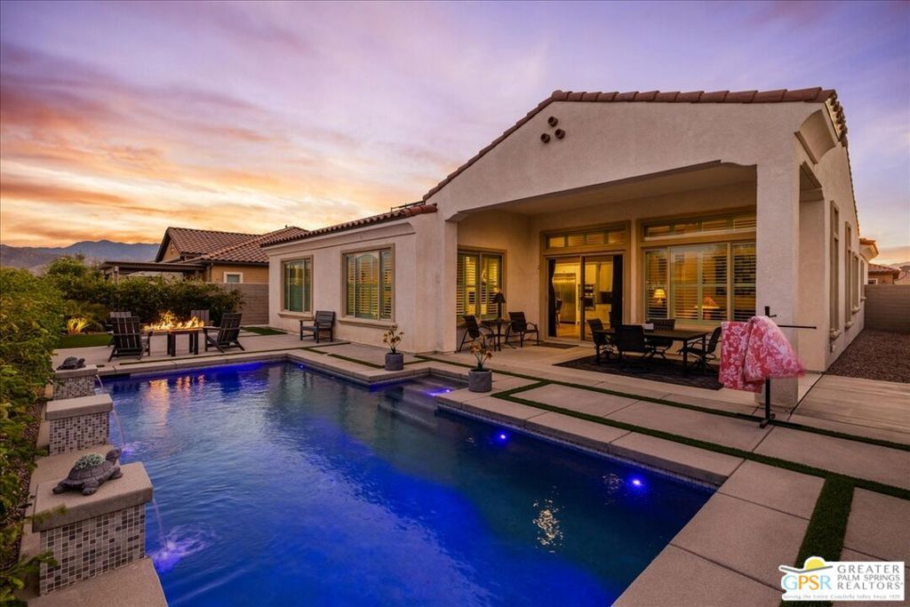Welcome to your private retreat in the heart of Del Webb's sought-after 55+ community. This beautifully appointed 3-bedroom, den and 2-bath home - Encore Series Plan 8, Spanish Serenity - blends upscale comfort with timeless design, offering a lifestyle of relaxation and refinement. Step inside to discover luxury vinyl plank flooring, custom plantation shutters, and designer ceiling fans throughout, setting the tone for an elegant and cohesive interior. The gourmet kitchen is a chef's dream, featuring a KitchenAid Professional Series appliance package with a built-in refrigerator, 42-inch upper cabinets with crown molding, striking black granite countertops, a full granite backsplash, and a large executive island with ample storage and seating - perfect for entertaining or casual meals. The kitchen flows seamlessly into a spacious family room with soaring 12-foot ceilings and a sunlit dining area adorned with a stylish fandelier, all designed to enhance natural light and open-concept living. Utilize the den as a formal dining room or bonus space for arts and yoga. Retreat to the primary suite, a peaceful haven with an ensuite bathroom featuring dual vanities, a walk-in shower with bench seating, and a generously sized walk-in closet. A private guest wing on the opposite side of the home includes two additional bedrooms and a full bath - ideal for hosting overnight guests or creating a home office space. Step outside to your covered patio and take in the serene views of your professionally landscaped backyard, complete with expanded hardscape, softscape, a custom gas fire pit, and your own private pool - an oasis for year-round enjoyment. Additional highlights include a spacious laundry room with abundant cabinetry and a utility sink, a convenient built-in shoe station, and an oversized 2.5-car garage with epoxy flooring and room for storage or a large vehicle. As a resident of Del Webb's premier active adult community, you'll have access to world-class amenities including a clubhouse, resort-style pool and spa, state-of-the-art fitness center, tennis courts, pickleball, and an array of social activities tailored to your interests. This is more than a home - it's a lifestyle.