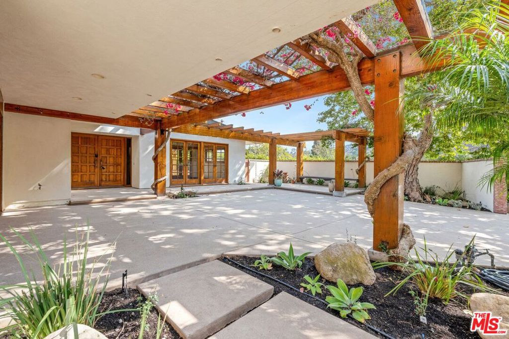 This spectacular glass and wood home and beautiful entrance will take your breath away. Experience Zen-like serenity. surrounded by verandas, flowering and terraced gardens, patios for outdoor dining & large side lawn for enjoying outdoor activities. Designed by Malibu Architect, Doug Rucker. Located on a large private lot with tranquil mountain views & your own hillside garden, it features walking paths along recently landscaped rock terraced landings, many mature fruit trees, including avocado, fig, guava and lemon, plus rose garden. Interior boasts skylights with remodeled gourmet kitchen featuring Center Island breakfast bar & stainless-steel hood. Formal dining room & living room include slate fireplaces, hard-fired Spanish tile flooring, indirect lighting, & French doors open to wrap around patios. First floor primary ensuite. Walk-in closet & French doors out to patio. On second floor boasts beautiful hardwood floors in both Bedrooms with views from balconies overlook inviting new Courtyard entry & mountains. Access to private Malibu West Beach Club on the sand with private locker. Vintage Market Shopping Center, Central Malibu Shopping. Beauty, Comfort and all you need for your new Home!