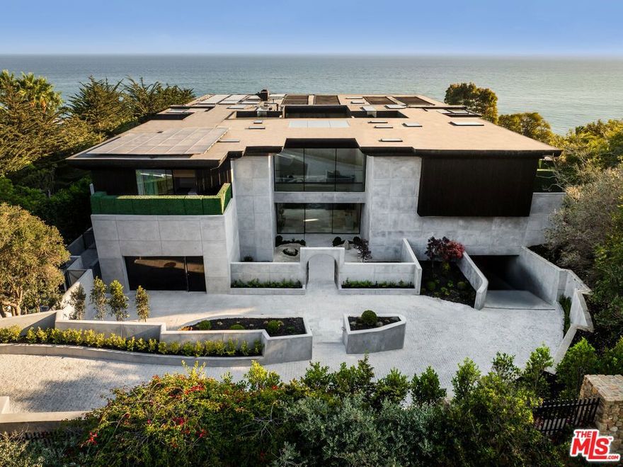 There are homes you live in and there are homes that live forever. Welcome to Simka Malibu - an awe-inspiring creation by "God's Architect" Kris Halliday. Thirty thousand square feet of architectural permanence rising from the bluffs of the Pacific, conceived as both fortress and sanctuary. A location chosen with the foresight of a thousand years thoughtfully positioned, engineered, and constructed with resilience in mind - designed to meet the challenges of fire, earthquake, tsunami, mudslide, and storm erosion. Built with over 7,300 cubic yards of super-reinforced concrete, Simka is a monument to permanence. Every line, every proportion, every material was shaped by one mind, one vision, one creation. The result is not just architecture, but a living work of art. Defined by bold lines of concrete and glass, softened by sculptural landscaping and curated natural stones from around the world, the estate embodies GA's philosophy of Brutality  Vitality - where strength is balanced by serenity, and concrete itself is reimagined into a velvet-like presence. Entry unfolds through a secondary gated entry into a tranquil zen courtyard and stone pathway, revealing interiors where floor-to-ceiling glass dissolves the boundary between home and horizon. Simka is a sanctuary - built on Divine Masculinity, created to protect, nurture, and heal. Life here unfolds through sublime experiences: a 176-foot multi-level vein-matched stone pool with swim-up bar, sunken lounge, and dramatic viewing window merging seamlessly with the Pacific horizon. A world-class theater with a 235-inch LED screen, Dolby Atmos sound, and Atelier Italian leather recliners rivals the world's finest private cinemas. A Japanese tea room - a sanctuary within the sanctuary - offers profound quiet. The full commercial kitchen easily supports gourmet cooking for up to 200 guests, complemented by terraces for al fresco dining, shaded loggias, and an outdoor kitchen for endless gatherings. Throughout, water and nature flow: Japanese gardens, waterfalls, meditation courts, koi ponds, and pathways that weave stillness into daily life. Swinging daybeds, a circular fire lounge, and open-air courtyards transform relaxation into ritual. For wellness and longevity, Simka offers a full spa, cold plunge, sauna, treatment rooms, and a state-of-the-art gym with underwater pool windows. A nightclub, private guest suites, and an underground 10-car garage complete the lifestyle offering. The 1,800 sq ft primary suite is a private sanctuary suspended above the waves, with its own hot tubs, fireplace lounge, and spa-inspired bath. Additional suites echo this intimacy, blending organic textures, curated furnishings, and panoramic ocean views. Every detail, down to marble-clad powder rooms designed as art, speaks to permanence and intention. With 10 bedrooms, 20 bathrooms, and seamless indoor-outdoor living, Simka is monumental yet intimate - enduring yet ethereal. Not built for a decade or a generation, but for centuries. Simka Malibu - architecture for eternity.