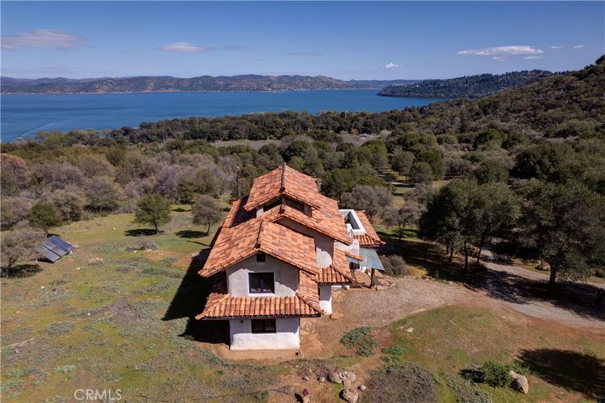 Tucked away in one of Northern California’s most picturesque settings, this extraordinary estate offers a rare blend of natural beauty, unique design, and sustainable living. Set on approximately 30 acres, the property includes riparian rights for lake irrigation, a domestic well, and an expansive 1,800-square-foot custom-built barn with a loft and kitchenette—perfect for storage, entertaining, or creative use.

The main residence is a thoughtfully crafted, two-story, four-bedroom, three-bath home built with sustainability in mind. Thick, extra-wide walls and plaster interiors provide excellent insulation, while stained concrete floors and an open-concept living, dining, and kitchen area create a spacious and modern atmosphere. NanaWall windows retract to seamlessly blend indoor comfort with the stunning outdoor surroundings, offering breathtaking views of the lake, vineyards, and Mt. Konocti from the northeast-facing aspect.

Throughout the home, artisanal touches like copper accents, wrought iron features, slate, and other natural materials lend a timeless character and rustic elegance. The vintage charm continues across the grounds, where you’ll find a manageable five-acre old vine Zinfandel vineyard, a walnut and fig orchard, and a full-size chicken coop.

In addition to the main house and barn, the estate includes two separate guest or worker residences: a one-bedroom, one-bath manufactured home and a one-bedroom, one-bath rustic cabin—ideal for hosting visitors or supporting small-scale agricultural operations. Multiple trails wind through the property, perfect for hiking, horseback riding, or simply enjoying the serene landscape.

Whether you're looking for a private sanctuary, a boutique vineyard venture, or a multi-use retreat, this property offers endless potential in one of Lake County’s most coveted locations!