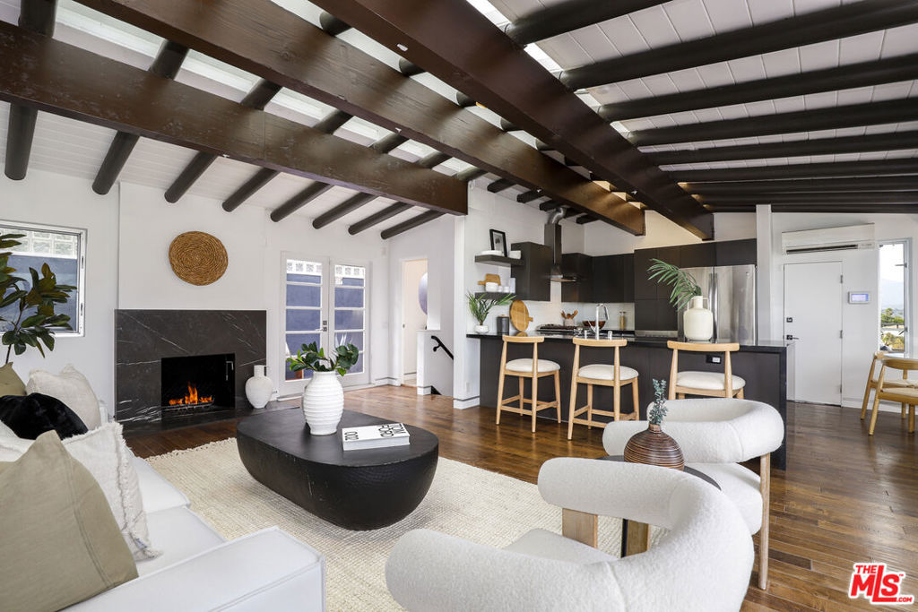 Perched in the heart of Los Angeles, this beautiful two-story Silverlake home boasts 2 bedrooms and 3 bathrooms, offering the perfect canvas for your dream lifestyle. As you enter, you're greeted by a light-filled, open-concept living area that seamlessly blends the kitchen, dining, and living spaces. The living room is a showstopper, featuring soaring ceilings with exposed wooden beams that add character and warmth. A sleek fireplace serves as a focal point, promising cozy evenings and intimate gatherings. The kitchen is a culinary enthusiast's dream, boasting modern gray cabinetry, high-end stainless steel appliances, and a stylish range hood. Ample counter space and a thoughtful layout make meal preparation a joy, while the adjacent dining area allows for seamless entertaining. The primary bedroom is a true retreat, offering a generous size of space. Bathed in natural light, it features a luxurious en-suite bathroom and ample closet space. The second bedroom is equally inviting, providing a versatile space for guests, a home office, or a personal sanctuary. Each bathroom is a testament to modern design, with sleek fixtures, spacious vanities, and a perfect balance of form and function. The primary bathroom boasts a large soaking tub, ideal for unwinding after a long day. Throughout the home, large windows frame stunning views of the Los Angeles landscape, including the reservoir and Downtown LA creating a constant connection to the vibrant city beyond. Energy-efficient features, including a modern HVAC system and an EV car charger ensure year-round comfort while minimizing environmental impact. This property isn't just a home; it's a lifestyle. With its prime location, you're perfectly positioned to enjoy the best of Los Angeles living. Whether you're hosting friends on a warm evening or enjoying a quiet moment with a book, this home offers the perfect backdrop for creating lasting memories. Embrace the opportunity to elevate your daily life in this meticulously designed urban oasis. Your dream of sophisticated, comfortable living in the heart of LA starts here.