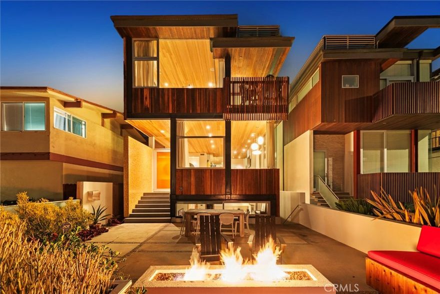 26 9th Street is an architectural masterpiece designed by Robert Thibodeau of D|U Architects, who has been featured in Dwell magazine. offering the ultimate blend of modern design, functionality, and coastal luxury. Each detail has been meticulously crafted, from expansive ocean views on every level to high-end finishes and custom seating and storage throughout. Perfectly positioned on an oversized ocean view walk-street lot, just steps from the sand and downtown Hermosa Beach, this breathtaking 4,168 square feet living space offers 5 bedrooms, 5 bathrooms, and a three-stop elevator. The main level is designed for effortless entertaining with a sleek open-concept kitchen, which opens into a large outdoor deck. The living area is a true showpiece, showcasing 13-foot vaulted redwood ceilings, windows that invite in natural light, wraparound built-in seating with hidden storage, and flush cabinetry. A floating staircase leads to the primary suite, where you’ll find two walk-in closets, a fireplace, a private deck, and sweeping ocean views. The spa-inspired bathroom features heated floors, towel rack, and a custom window above the soaking tub that opens to welcome in the coastal air. Three additional bedrooms on this level offer versatility for guests, a home office, or children’s playroom, with one suite enjoying its own private deck with views and en-suite bath. A separate laundry room on this floor enhances everyday convenience. The lower level is impressive, hosting a full guest suite ideal for extended stays and a separate living area with a built-in projection system, custom cabinetry, and wet bar. It also provides a private entrance with direct access to the front of the home and guest parking. The newly epoxied garage accommodates two vehicles, with three additional designated spaces, providing rare parking for up to five cars. Relax on the front patio with friends around a lit fire pit at sunset, just steps from the beach. Included are custom seating and an outdoor shower. For more private sunbathing, an extraordinary rooftop deck offers panoramic views from Catalina to Malibu. This premier vantage point is unrivaled for South Bay fireworks, summer concerts, and breathtaking sunsets, making it an entertainer’s dream. With flexible living spaces, refined finishes, and one of the most spectacular rooftops in Hermosa Beach, 26 9th Street seamlessly combines the aesthetics of modernism with the space and creature comforts only seen in desirable homes.