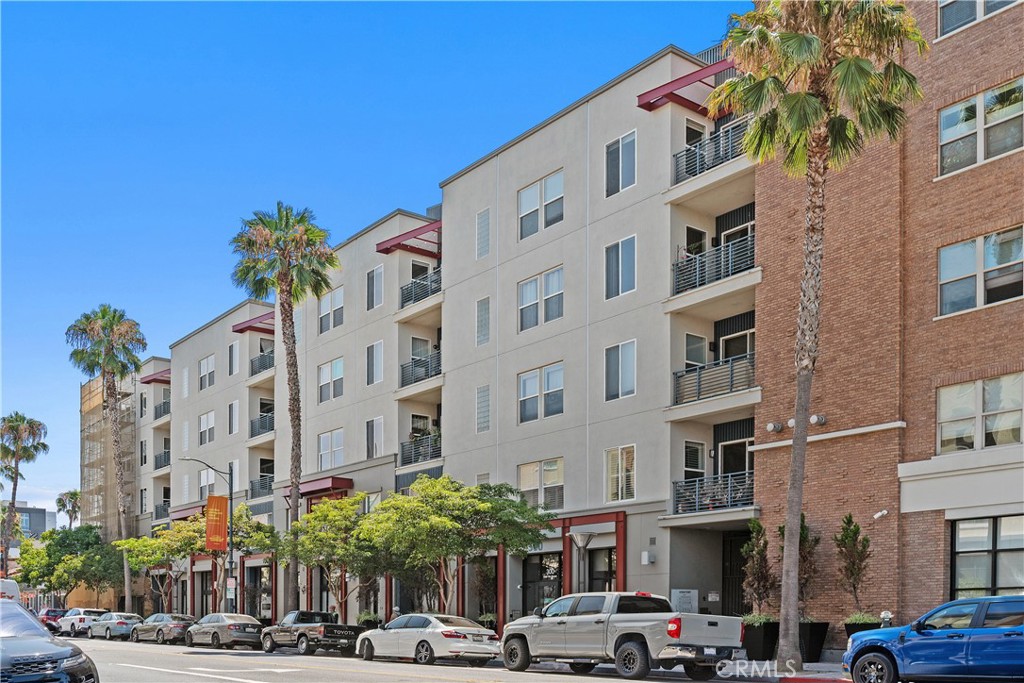 Experience coastal luxury living at Blu, a premier condominium community in the heart of the East Village Arts District in Downtown Long Beach—just blocks from the beach, Shoreline Village, and within walking distance to top restaurants, bars, and entertainment, with convenient access to the Metro Blue Line for an easy commute to Downtown Los Angeles. This spacious second-floor end unit features two bedrooms and two bathrooms, with a separate den/office area, and an open-concept layout with soaring 9-foot ceilings, new engineered hardwood floors, new plantation shutters, blackout shades, ceiling fans, and abundant natural light. The modern kitchen offers granite countertops, new stainless steel appliances, a glass tile backsplash, soft-close cabinetry, and seamless flow into the living area, perfect for entertaining or everyday comfort. The primary suite includes a walk-in closet with custom organizers and a spa-like en-suite bathroom with dual sinks, an oversized walk-in shower, and a built-in bench, while all closets throughout the home are professionally outfitted for maximum storage. Additional features include a private laundry room with built-in shelving, a wrap-around balcony with courtyard views and ocean breezes, two assigned side-by-side parking spaces in a secure gated garage, and a private 10' x 5' storage unit. Blu’s upscale amenities include a boutique-style lobby with a reading area and coffee bar, a courtyard with a fireplace, putting green, BBQ area, a fitness center, and a sports lounge with a billiards table and four TVs, including movie and sports channels. Pet-friendly and equipped with an upgraded security camera system, this exceptional home offers a rare opportunity to enjoy stylish, modern living in one of Long Beach’s most desirable communities.