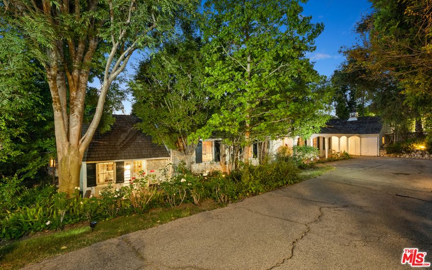 Positioned along a quiet street within the exclusive lower Bel Air neighborhood, this English-style country home was designed by renowned architect Gerard Colcord in 1938. Spanning over 4,200 SF of living space, the main home includes 3 bedrooms as well as maids quarters, while resting upon a rare 36,000 SF lot, ideally positioned for any future recreations or endeavours desired. Throughout the home, signature touches from Gerard Colcord are featured, such as dramatic stone fireplaces, intricate woodwork, and impressive hand-hewn exposed beams that magnify the various vaulted ceilings. In the main home, an arched front porch leads into a gracious entrance hall which unfolds into a comfortable living room, formal dining room, white-washed kitchen, and rear lanai and family room wrapped in windows to take in views of the property. Ample-sized bedrooms, authentic bathrooms, built-in office nook, and an original butlers pantry round out the main home. Alongside the main home is a grand pool with spa, accompanied by a substantial guest house, complete with an additional entertainment space, kitchen, bedroom, and bathroom. Additional features of the property include a 2-car garage with a 3rd bay accessed via a porte-cochre, a large exterior patio, and ease of access to all of LA.