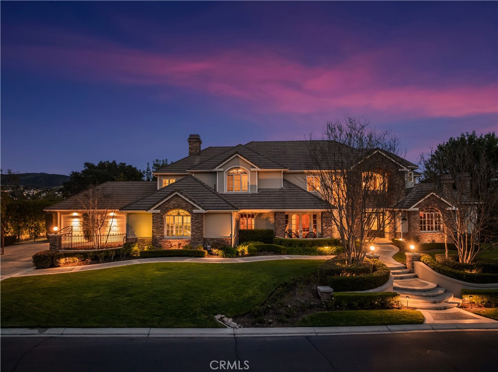 Set on over an acre, this remarkable Woods Estate offers breathtaking sunrise views of the picturesque Coto de Caza Valley. From the moment you enter, you’ll be captivated by the impeccable quality of construction and thoughtfully designed spaces that blend luxury with comfort.
The elegant executive library is perfect for quiet reflection or productivity, while the formal living areas exude sophistication and warmth. The well-appointed kitchen seamlessly flows into the great room and bar, creating an ideal setting for both everyday living and memorable gatherings with friends and family. Every detail has been meticulously crafted, featuring custom finishes such as distressed hardwood floors, imported granite and marble, stunning custom built-ins, high ceilings, solid core doors and three handsome fireplaces. The impressive 1,000+ bottle temperature-controlled wine cellar is perfect for the connoisseur. The thoughtful architectural design includes four generously sized upstairs bedrooms, each complete with ensuite bathrooms and walk-in closets. A large upstairs bonus room provides versatile living space and could easily be transformed into the sixth secondary bedroom. Children will enjoy their own dedicated study area with built-in desks, while the luxurious master suite offers a remodeled bathroom that boasts spectacular views. At the heart of the home, the kitchen and great room shine with exquisite cabinetry, spacious layouts, an inviting breakfast nook, stainless steel appliances, and expansive windows that bring the outside in. Step outside to discover the immaculate grounds, featuring a dreamlike backyard complete with a stunning pool, spa, built-in BBQ, and sports court. This outdoor paradise is perfect for relaxation or entertaining, surrounded by lush landscaping that enhances the estate's allure.