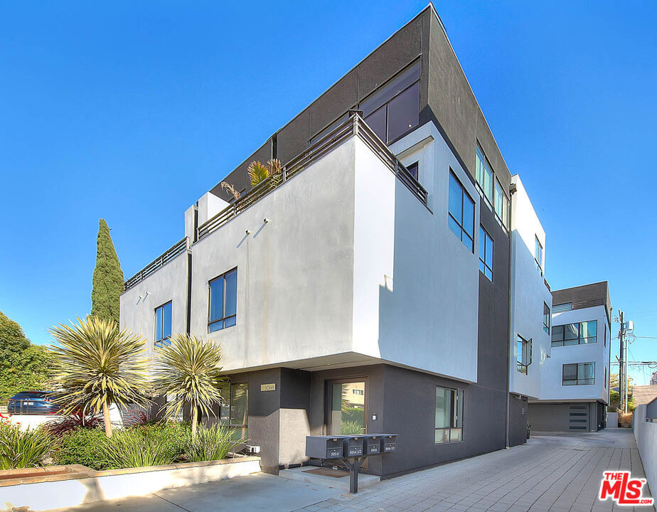 Nestled just moments from Hancock Park, this striking architectural single-family residence offers the perfect blend of design, comfort, and location. Built in 2018 and impeccably maintained, showcasing soaring 17-foot ceilings, exceptional natural light, and curated high-end finishes throughout. The imported Leicht kitchen anchors the expansive main level, featuring a sleek, modern design with a generous bar area ideal for entertaining. The open-concept floor plan flows effortlessly from the dramatic living room to an upper loft/flex space, creating a dynamic yet functional layout. Enjoy seamless indoor-outdoor living with dual terraces offering both southern and northern exposures, views of the downtown skyline and the Hollywood Hills. Floor-to-ceiling sliders flood the interior with light and provide easy access to private outdoor spaces. The luxurious owner's suite features a spacious walk-in closet and a spa-inspired bath complete with an oversized shower. Additional conveniences include a private two-car garage with direct entry and a dumbwaiter for effortlessly transporting groceries to the kitchen level. Situated within an exclusive, gated enclave of only four homes, this rare offering combines privacy, modern elegance, and an unbeatable location. A true gem in the heart of the city.