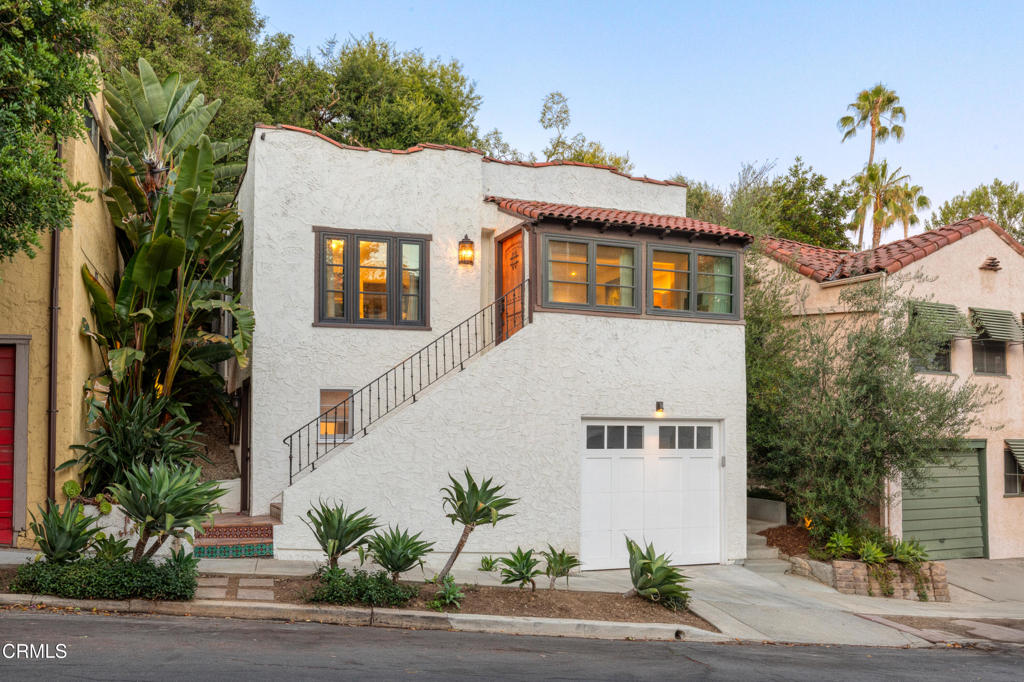 Perched above the street in one of Silver Lake's most sought-after neighborhoods, this beautifully preserved 1920s Spanish-style home offers timeless character blended seamlessly with thoughtful modern updates. The main residence features two generously sized bedrooms and two elegantly remodeled bathrooms upstairs, offering comfort and style in every corner.Classic arched windows, hardwood floors, and original details provide a warm, inviting atmosphere, while the updated kitchen and bathrooms ensure functionality and convenience for contemporary living. A separate guest unit with its own private entrance and ensuite bathroom makes the perfect space for visitors, a home office, or rental potential.The tiered yard offers multiple outdoor spaces ideal for entertaining, gardening, or simply enjoying the sweeping hillside views. Recent upgrades include a brand-new garage, a comprehensive foundation retrofit, and an enhanced drainage system, ensuring long-term peace of mind.This is a rare opportunity to own a piece of Silver Lake history--rich in charm, move-in ready, and nestled in a tranquil, elevated setting just minutes from shops, restaurants, and the reservoir.