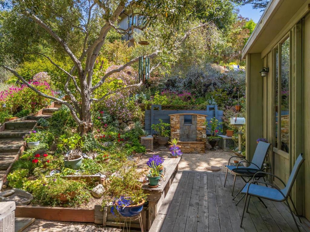 A hidden gem in Carmel, this redwood home was thoughtfully designed in the mid-1960s by George Beck, a local builder and artist inspired by Frank Lloyd Wrights organic and mid-century modern architecture. Crafted for his own family, the home reflects Usonian ideals with redwood-framed glass doors, a flowing indoor-outdoor layout, and a rare connection to the land. The upper level of about 1,540 sq ft offers two bedrooms, 1.5 baths, a modern kitchen, and a dining room with garden views. Expansive windows artistically frame views of hills and beautiful trees, flooding the home with natural light. Below, a separate entrance leads to a flexible 510 sq ft two-room suite with a full bath, ideal for a home office or guest retreat. Three decks provide space for outdoor living and reflection, with views across the rolling hills of Fish Ranch. Garden paths wind through a tapestry of succulents and seasonal blooms, planted and lovingly tended by the original family. Just minutes from Carmel Beach and the charming boutiques of Carmel-by-the-Sea, this home offers a Big Sur-like sense of escape with the convenience of Carmel living.