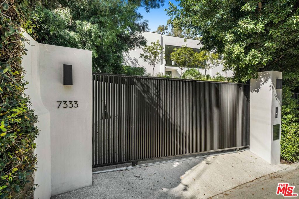 Stunning brand-new construction in the Hollywood Hills! This contemporary 5 bedroom & 6 bathroom masterpiece is sited up a long private driveway on an over 22,000sf lot and nestled in the star-studded enclave on Woodrow Wilson Drive. Enter this lavish gated estate home through an oversized front door to a grand living room bathed in natural light with elegant marble fireplace, soaring ceilings and large picture windows. Thoughtfully selected finishes include custom cabinetry, honed marble counters, designer fixtures and beautiful white oak hardwood flooring throughout. Chef's kitchen is equipped by top-of-the-line appliances and a butler's pantry. Adjacent dining area is the ideal setting to entertain your dinner guests while they gaze through walls of glass upon the gorgeous grounds and sparkling pool as their backdrop. Downstairs also features a wet bar, barbeque area, guest bedroom that can be allocated as a theater or office and a mudroom off of the three-car garage. Upstairs consists of 3 additional guest bedrooms and a spacious primary suite with luxurious bathroom, dual closets, private balcony, and serene views of the manicured hillside. Conveniently location near popular shops and trendy restaurants in Studio City, the iconic Hollywood Bowl, Runyon Canyon hiking trails, Universal City Walk and Burbank film studios.