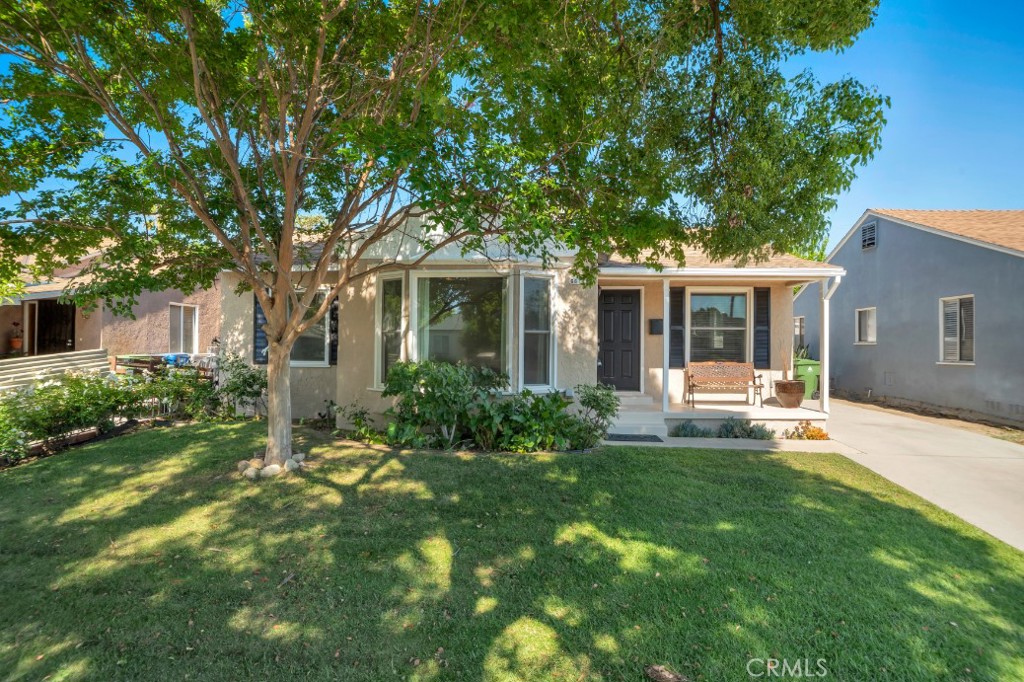 Nestled on a charming tree-lined street in Lake Balboa, this well-maintained 3-bedroom, 1-bathroom home offers timeless appeal and thoughtful updates on a generously sized 6,000+ sq ft lot. Original hardwood floors run throughout the main living areas and bedrooms, while tile accents the kitchen and bath. A floor-to-ceiling bay window floods the living room with natural light and flows into the dining room, creating a seamless layout for everyday living. The kitchen features crisp white cabinetry, dark gray countertops, stainless-steel appliances, a window above the sink, and connects to a dedicated laundry room with extra storage and backyard access. Recessed lighting, dual-pane windows, copper plumbing, relined sewer, and a newer HVAC system add comfort and peace of mind. All three bedrooms are bright and equipped with ceiling fans; one offers dual access from the hall and kitchen, plus direct entry to the covered back patio. The spacious primary bedroom includes two closets for ample storage. Outdoors, the expansive backyard is a true retreat, complete with a tile-floored pergola patio, a lush lawn shaded by mature trees, and plenty of space for a future pool or garden. A long driveway leads to a detached 2-car garage, providing generous parking and potential for ADU conversion. Conveniently located near Lake Balboa Park, golf courses, local dining, shopping, and easy access to the 101 and 405 freeways.