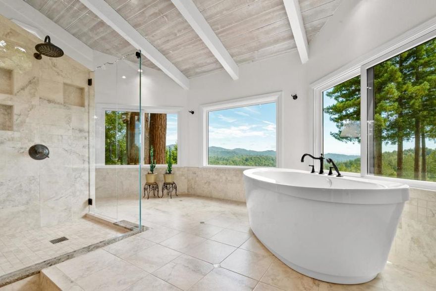 Perched above the treetops with sweeping 40-mile views, this stunning retreat brings the outdoors in with expansive picture windows framing the surrounding redwoods and forested ridge lines. Every room feels like a sanctuary, filled with natural light and connected to nature. The kitchen is warm and welcoming with granite countertops, custom cabinetry, and high-end appliances, flowing into a cozy dining space with panoramic vistas. The spa-like primary bathroom is elegant, serene, and thoughtfully designed for relaxation. Step onto the spacious deck and soak in the hot tub, tend the raised garden beds, or relax on the incredible bench built around a redwood tree, an unforgettable spot that captures the magic of this home, a rare blend of meticulous care, comfort, and nature. The location is ideal for Silicon Valley or Santa Cruz commuters or those working remotely. Experience the peace and beauty for yourself - you wont want to leave.