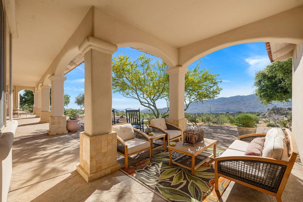 Welcome to your serene mountain escape, situated on 2.52 ACRES of landscaped gardens and flowering trees. This exceptional Santa Barbara style 2300+sqft home development is bordered by National Forest land, offering both tranquility and convenience, just a short 15 minute drive to world class shopping on El Paseo. Enjoy cooler temps, spectacular panoramic views of mountains and city lights from every angle. The living area and bedrooms open via 8' wood french doors, to the magnificent covered front patio. The interior doors are also solid wood 8' tall plus wood beamed ceilings in almost all rooms. The split bedroom floor plan w/primary on one side and two bedrooms on the other, allows for maximum privacy. The primary suite has two walk in closets, an oversized freestanding soaking tub, w/views and a walkout from the bedroom to a sitting area on the veranda. The renovated kitchen with work island, has upgraded appliances, custom cabinets and opens to breakfast, dining and living areas, all with commanding views through expansive windows and doors. There are three zones of heating and cooling, plus a backup Generac power generator. The three car garage has tons of builtin storage space plus EV- charging station. The exterior has beautifully maintained terraced gardens plus many varieties of trees, multiple outdoor seating areas and paver driveway leading directly to your garage. Take the time to make an appointment and come see this exceptional home. Thanks