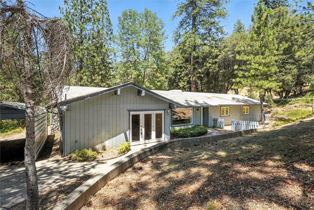 Great opportunity for your own home in Ponderosa Basin and enjoy the mountain setting. Spacious home includes separate office and storage room, in addition to living room with bay window, family room with fireplace, dining area with French doors to backyard, kitchen with breakfast bar, as well as laundry room with pantry closet, two bathrooms, and three bedrooms. Primary bedroom suite includes two separate walk-in closets, double sinks, and compartmented commode and shower. Corner bedroom offers walk-in closet, while front bedroom has sliding closet doors. With .83-acre, you'll have a sense of privacy and seclusion, with plenty of yard space to enjoy. Paved driveway provides access to two standard carports and one RV-height carport. And you're just a short distance to Sierra National Forest, the east fork of Chowchilla River, and both dirt roads and hiking paths in the National Forest. First time for this well-loved home to be on the market -- don't miss your chance to make it yours!