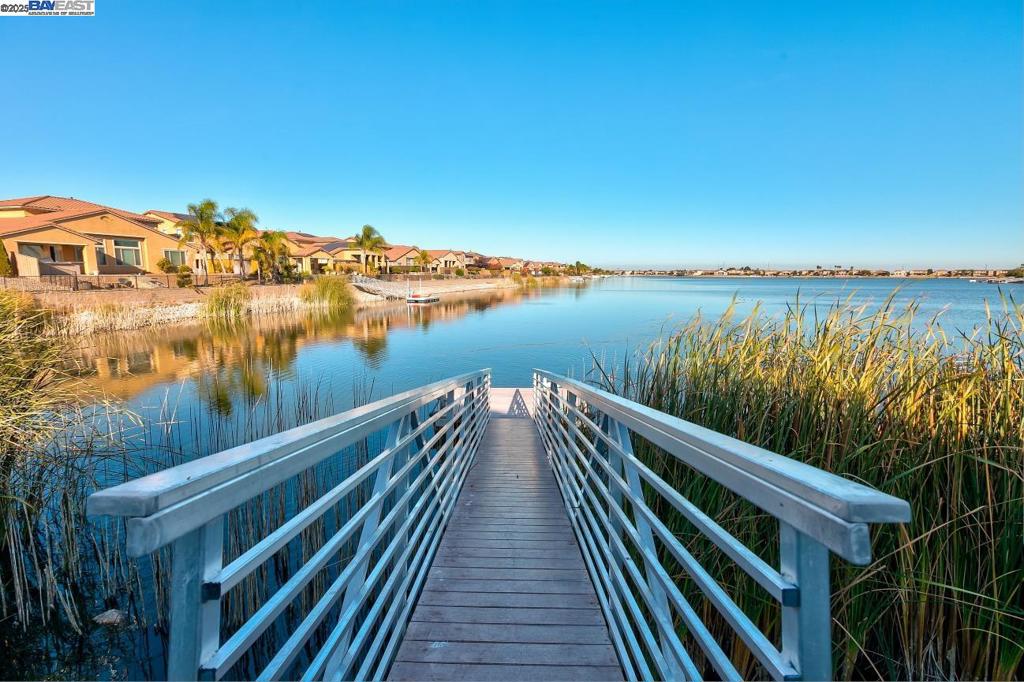 Dream lakefront living with 24-hour security, your own private dock, and some of the best catch-and-release fishing in the region! This spacious waterfront home features a bright, open floor plan with large windows to capture serene water views, vaulted ceilings, and seamless indoor-outdoor flow. The updated kitchen offers ample storage and connects to a welcoming family room—perfect for entertaining. The primary suite features peaceful lake views, generous closet space, and a private bath. Step outside to your deck and enjoy sunrises over the water, or drop a line right from your dock. The stocked lake includes largemouth bass (1.5–2 lbs, with trophy catches over 10 lbs), catfish, and bluegill. Whether boating, relaxing, or reeling in the next big one—this is year-round resort living at its finest. Gated community provides security and privacy. Rare opportunity—schedule your private showing today!
