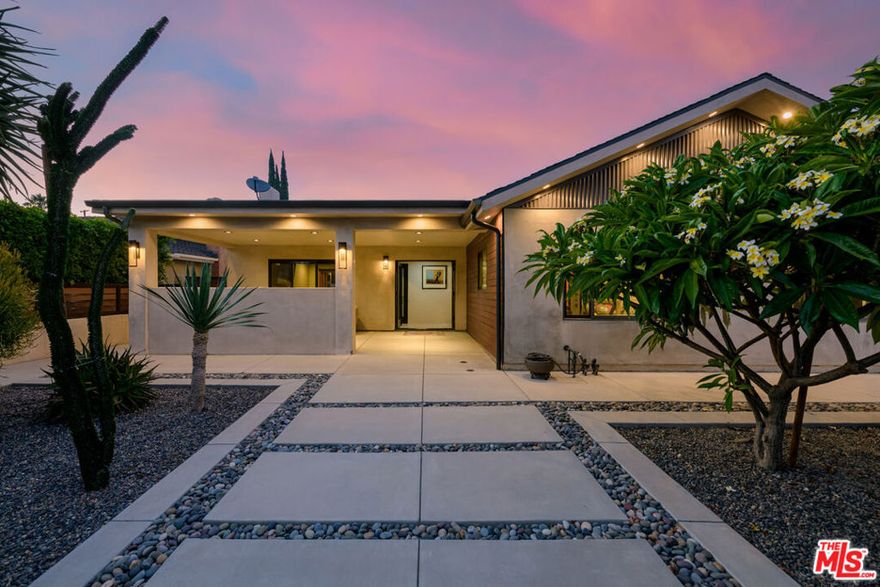 Beautifully renovated with designer details, this 3 bed / 2 bath home blends high-end finishes and thoughtful upgrades in a charming Valley locale. Featuring custom concrete walkways, serene water fountain, lush drought-tolerant landscaping and garden, Mexican river rock accents, and curated decking. The exterior includes smooth Santa Barbara stucco, an outdoor pool shower, custom accordion doors and pergola, iron gates, and Brazilian Ipe wood privacy fencing. Inside, enjoy real oak floors, South American porcelain tile, abundant natural light evoking an indoor-outdoor flow, and custom automatic blinds. The epicurean kitchen offers island seating, modern appliances, and open access to the formal dining room, with seamless transitions to al fresco dining by the pool. The primary suite boasts a spa-like bath with a Roman Jacuzzi tub, custom vanity, private outdoor seating, and stunning Missoni garden wallpaper. The backyard features a remodeled pool with Pentair system and an adjacent outdoor fire pit for relaxed evenings. The detached 2+ car garage, with epoxy floors and dual doors, offers ideal flex space for a gym, office, or creative studio. A true gem with exceptional private outdoor living, this home is a perfect combination of original architectural integrity and resort-style design. Close to The Vineyards at Porter Ranch,  Fashion Center shopping, dining, entertainment, fitness, and local award-winning schools! Welcome home.
