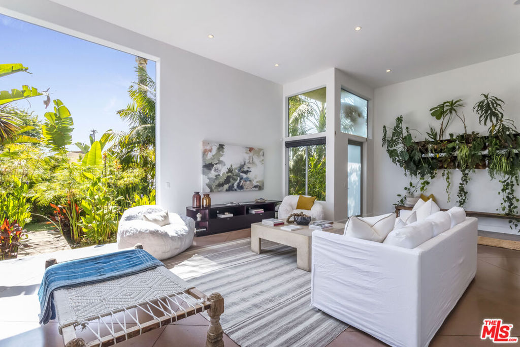 Venice Hideaway for the Next-Gen Elite. Step from the sand into your private resort in the coveted Silver Triangle, minutes to Abbot Kinney's Michelin-star scene, the historic canals, and world-class Marina. Designed for the jet-setter who values both style and serenity, this revamped oasis blurs the line between indoors and out with a 14-ft disappearing glass wall that frames a sleek koi reflection pond. Elevate your backyard Vibes by toasting the sunset around a lava-rock fire pit, letting the low-maintenance turf host spontaneous lawn games, and drifting off to the soundtrack of a custom lava rock fountain. The main Level is an entertainer's dream, featuring polished concrete floors and a living green wall that sets a modern tone. At the same time, the chef's kitchen features soapstone counters, a six-burner gas range, purified water on tap, and a glass-wrapped island. The living area's statement fireplace, clad in reclaimed ebony wood, anchors the open-plan space. The Penthouse-Style primary wing is pure indulgence: private terrace, wood-burning fireplace, five-piece spa bath with jacuzzi, and an oversized walk-in closet ready for tomorrow's fashion drops. Upstairs boasts Brazilian cherry floors that lead to two generously sized guest suites and a spa bath with a soaking tub. Catch ocean breezes and city lights from the rooftop deck, then roll into your three dedicated parking spots, an unheard-of luxury in Venice. Live the coastal-cool lifestyle without compromise. This is the Venice address that turns everyday life into a perpetual getaway.