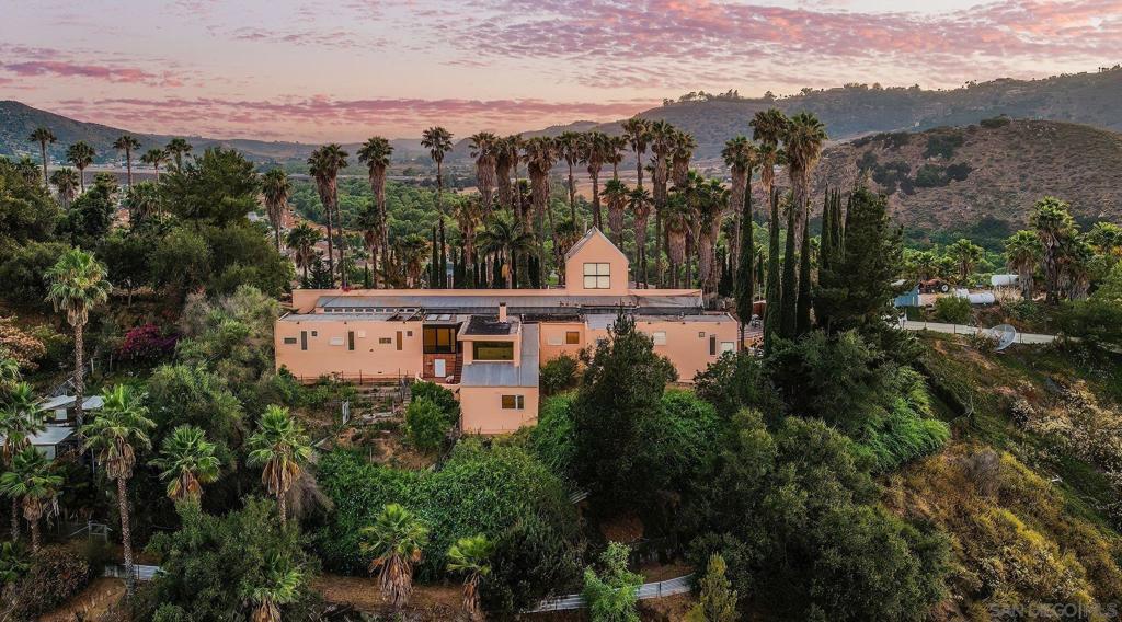 Discover your own slice of paradise with this custom Spanish-style home set on an expansive 93.36-acre lot in Fallbrook with private well producing all the water for the entire property. This property has overlying water rights to the San Luis Rey River, giving you an excess of water for the entire property. Boasting panoramic views and fresh paint, this move-in-ready property offers endless possibilities. Whether you're looking for a horse farm, active extreme riding, or space for motorcycles, this land provides the perfect setting. For those seeking an even grander opportunity, embrace a once-in-a-lifetime chance to own a breathtaking 93-acre orange and avocado farm complete with a comprehensive well water system and a stunning custom Spanish-style home overlooking lush, fruitful groves. This hilltop estate features a swimming pool & jacuzzi, offering breathtaking panoramic views of the surrounding mountains, citrus groves, apple orchards, avocados, and the San Luis Rey River. The property includes approximately 25 acres of flat land and rolling hills, ideal for avocado cultivation. Zoned A70/A72, it allows for agriculture and subdivision with 4-acre minimum lot sizes. A diverse variety of fruit trees flourish here, including Valencia Orange, Satsuma Mandarin, Avocado (Hass, Gwen, Lamb & H287), Fuyu Persimmon, Apple, Pummelo, Blood Orange, Kinnow Mandarin, and Peach. A mixed garden offers apricot, plum, apple, grape, almond, olive, and blackberry, with ample room for additional plantings. This property is fully equipped with two high-producing wells, each 65 feet deep and capable of pumping 1,000 gpm, with current production at 340 gpm at 65 psi. One well has a 20 hp submersible pump, and the other is diesel-driven with a gearhead on a lineshaft turbine. The water is pumped to the top of the hill where it is filtered for the home and supplies water for the home and entire farm. The home has a unique floor plan which includes four bedrooms, a living room, family room, loft, two fireplaces, two offices, and two balconies perfect for taking in the views. The home offers multiple living spaces on different levels, providing privacy and convenience. This land is rich in history, having been cherished by the seller's family for generations. The home is just off Pankey Rd, which was named for one of the family members who played a crucial role in developing Fallbrook's citrus and avocado industry. With its immense potential and versatile appeal, this property offers a once in a lifetime opportunity to continue a storied tradition while forging your own legacy.