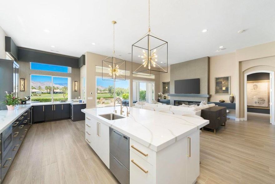 Looking for the show stopper!? THIS IS IT! Fully remodeled Sedona floor plan with jaw dropping mountain views over 2 fairways, grants this home with a special one of a kind allure! No detail was overlooked when renovating this property. When entering, you are welcomed by an enhanced entrance & grand entry double doors as you are greeted with spectacular views, tall ceilings, new flooring, foyer chandelier, graceful glass wall sculptures. This home is adorned with contemporary decor including exquisite custom cabinetry, stunning lighting fixtures, large modern glass fireplace. You will be enticed by a truly entertaining home featuring a gourmet kitchen that expands the length of the entire great room anchored by a bar overlooking the golf course with 2 wine refrigerators & ice maker. The kitchen features large island, new 5-burner Thermador gas cooktop, 2 Fisher & Paykel drawer dishwashers, Zephr hood fan, Sharp drawer microwave as well as Kitchenaid refrigerator & oven. Entertain in formal dining room or on the patio with new BBQ island featuring fire magic windowed BBQ, fire pit, modern patio furniture, new landscape & lights to enjoy breathtaking sunsets. The primary bedroom ensuite includes spa-like bathroom large porcelain tiles, tub, large shower, quartz countertops with exceptional lighting fixtures. The two guest rooms include ensuites, one is currently set up up as an office. An enclosed den/flex room provides optional sleep area for guests with built-ins including desk & closet. Bosch washer/dryer. This stunning home is being offered furnished per the sellers inventory list. One last bonus, it also has a Tesla EV charger!