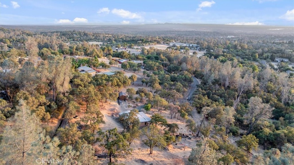 3 acres with stunning valley views at the end of a private road. This charming East Foothills home is just minutes from Lake Oroville, offering peaceful seclusion with convenient access to town. Features include warm wood-beamed ceilings, a spacious front porch perfect for soaking in the views, and a master suite with a relaxing soaking tub and large shower. The property also has an irrigation ditch at the top, making it ideal for gardening or landscaping. A cozy retreat with privacy, scenery, and charm — all in one.