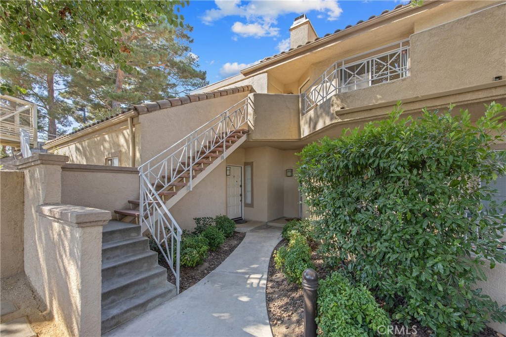 Stunning Upper Corner Unit Located in the Heart of Valencia. This Beautiful Home Boasts Soaring Ceilings and an Abundance of Natural Daylight compliments of the Living Room Balcony's Sliding Door. The gourmet Kitchen is a Chef's dream featuring Elegant Shaker style Cabinets, sleek Black Granite Countertops, a Stylish Glass tile Backsplash, under cabinet Lighting and Recessed Lighting. Design Details include Pull out Pantry doors, Pull out Spice Rack, and an Added Bar Area with Glass Display Cabinets, Perfect for Entertaining! A Wine Refrigerator and Stainless Steel Appliances complete the Upscale Kitchen. The Entry way is Adorned with Slate Flooring and Fireplace Surround and Custom Built-in Maple TV Stand with Shelves and Upper Shelving. Both Bathrooms have been tastefully Remodeled with matching Shaker-Style Cabinets, Black Granite Countertops, Updated Lighting, and Stone Tile Tub & Shower Surrounds, Offering a Spa-like Retreat. Additional Highlights Include a Smart Thermostat for energy efficient comfort, Keyless Entry, GE High Efficiency Front Load Stackable Washer & Dryer , and Motorized Shades in both Bedrooms. Sit back and Relax with morning Coffee or Evening Wine on the Living Room Balcony! Parking is a breeze with a One-car Garage, Plus an Additional assigned Parking Space. Residents also enjoy Incredible HOA Amenities including Resort-Style Pools, Spas and more! All of this and Located Walking Distance to Premier Shops, Dining & Entertainment making this a rare Opportunity to own a Luxurious Home in one of Valencia's Most Desirable Communities.