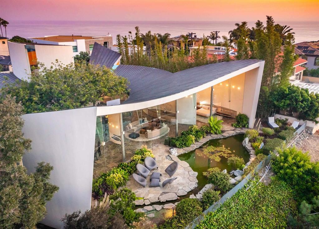 Superior Bold and Dynamic Contemporary Masterpiece. This unique distinctive free form structure rests upon the lush hillside within La Jolla framed by Coastal Vistas. Tucked away in a quiet Cul De Sac. Expansive single level approx 4,900 SF home, 3 bedroom, 3.5 baths with office, artist/loft/home theatre. 20 Foot floor to ceiling towering glass walls are both artistic and functional and act as a framing device for the unique structure itself. Fully enclosed private courtyard with protected glass walls, seamless indoor and outdoor living spaces open to expansive Coastal Vistas. Every custom detail is part of the whole 'LIVING IN ART" experience. Open Living/Great Room/Dining Room accented by crushed glass free form fire feature. Main Suite with disappearing doors and wall panels. Spiral staircase leads to artist retreat/theatre. Custom inset cabinets blend seamlessly into walls throughout. Gallery custom Kitchen with rough stone flooring and granite countertops. Backyard is completed by babbling water brook, tropical koi pond and natural canopy trees. Fully Furnished Luxury Long Term Rental. This barrier free design captures coastal views, downtown La Jolla, and the Golf Course. Stylish, Ultra Contemporary, Luxury Private Estate that connects to its natural surroundings.