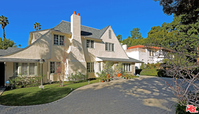 This inspirational French country estate and celebrity home designed by renowned architects, Elmer Grey and later Ted Grenzbach is a 5 bedroom, 7 bath property fronting one of Beverly Hills most distinguished streets. It overlooks a spacious backyard with fountain, pool and an extraordinary 2-story guest house/studio. This impressive home is perfect for entertaining with center entry that leads to an open floor plan connecting family, dining and living areas all of which flow into the expansive grounds. A state-of-the-art kitchen will please the most serious cook. Additional features include hardwood floors, 4 fireplaces, huge master suite with terrace, walk-in closets and 3 additional 2nd floor bedroom suites plus a first floor maids/office. The fully equipped guest house with loft and fireplace is fabulous and features gangster Bugsy Siegel's original bar. The 16,180 sq. ft. luxurious lot is beautifully designed and has been the backdrop for movies.