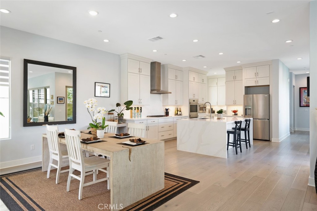 RELISTED!! PRICE IMPROVEMENT!! ! Welcome home to beauty and serenity in the newer Solis park neighborhood within the amazing Great Park community!! No expense has been spared in this amazingly upgraded 5 bedroom, 4 1/2 bath home. You will be immediately pulled into this bright and large home by the tall ceilings, floor to ceiling windows, and pristine wood flooring throughout. The great room is beautifully arranged and open to both the expansive kitchen and inviting dining area.. The main level boasts a highly upgraded chef's kitchen with an oversized island and luxurious stainless steel appliances, including a six burner range. The kitchen is complimented by upgraded quartz countertops and a custom backsplash. The main floor also includes a large on suite bedroom, with a full bath with walk in shower for multi generational living or guests. A separate half bath is located on the main level as well. The peaceful exterior has been upgraded with artificial turf, custom patio dining area, and a lovely garden space. The patio cover offers shade and privacy year round, and allows for outdoor dining in all seasons. the inviting front porch also offer two peaceful seating areas with large sliding glass doors to the large dining room and kitchen. As you head upstairs to the second floor you will notice the bright and airy loft at the top of the stairs with three amply sized bedrooms on one side. One bedroom is a complete on-suite, and the other two share a large hallway bathroom. All bedrooms include large walk in closets for maximum storage space. The main bedroom is oversized and upstairs on the opposite side of the house, for privacy and quiet living. The main bathroom is luxuriously appointed with a large asking tub, oversized walk in shower, and dual sinks. This home is equipped with a leased solar system, allowing for almost complete energy production with little or no monthly energy cost. Additionally, this home is fully appointed with recessed lighting throughout, customer window coverings with lifetime warranty, pre-wired for media, integrated speakers, and so much more!! This large Solis Park home is not to be missed!