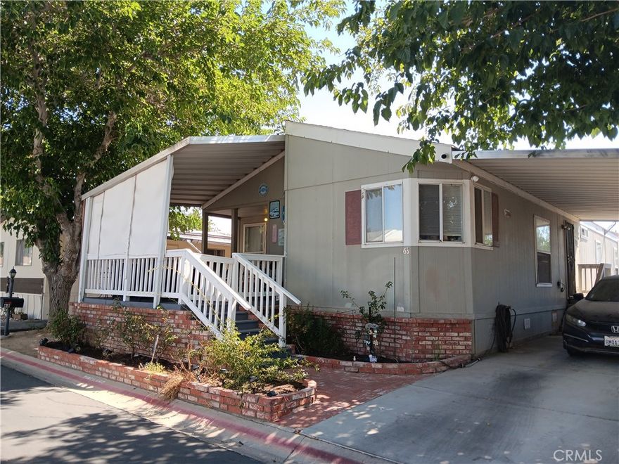 Light & bright & move-in ready!  Super nice home with newer flooring - laminate in living areas, tile in baths and carpet in bedrooms.  Fresh-looking neutral paint throughout.  Appealing floorplan with 3 generous bedrooms, including a big beautiful primary suite with large oval tub, separate shower, double sinks and airy feel.  Kitchen incorporates great counter and cabinet furnishings with central island convenient to the spacious dining area.  Other details include roomy closets and up-to date light fixtures.  You'll also love the shaded front porch with room to relax.  It's added outdoor living space!  All appliances included, even washer & dryer. Park is gated and loaded with quality amenities, including 2 pools, a spa, gym, community kitchen and huge recreation room for parties, games, classes, etc.  Come and see!