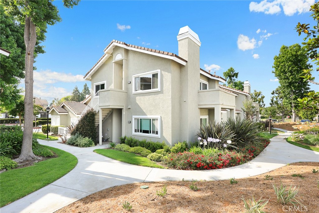 Welcome to Stonegate, located in the highly sought-after Woodbridge community of Irvine. This rare corner-unit Auburn model is bright and airy with beautiful greenbelt and treetop views from every room. Step into the spacious living room featuring vaulted ceilings and a cozy stone fireplace, flowing seamlessly into the formal dining area, which opens to a generous private balcony—perfect for relaxing or entertaining with stunning scenic views. The chef’s kitchen is a standout, boasting custom cabinetry, quartz countertops, stylish tiled walls, stainless steel accents, and a host of thoughtful upgrades.
The bedroom wing includes a dedicated laundry closet with side-by-side washer/dryer hookups. A remodeled bathroom showcases marble countertops, a custom vanity, and a private shower with stone and tile detailing, a custom showerhead, and a sleek sliding glass door. The primary bedroom is spacious, featuring vaulted ceilings, a ceiling fan, and an entire mirrored wardrobe wall. The second bedroom, ideal for guest or home office. Additional highlights include central air, a private garage (#549) with remote access, and a covered parking spot (#72), plus ample guest parking nearby. Enjoy all the award winning schools and the amenities of Woodbridge: scenic walking trails, lush parks, sparkling pools and spas, top-rated schools, and a wide range of sports facilities including tennis, volleyball, basketball, and handball courts. Plus, the community’s stunning lake with mountain views adds a resort-style feel to everyday living.
