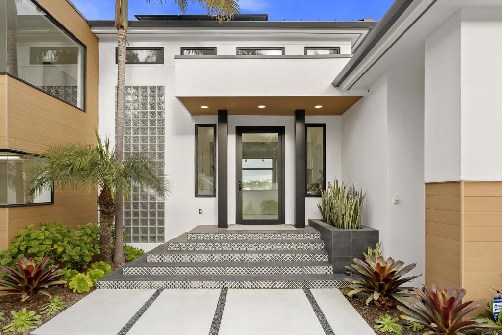 Set behind private gates in Solana Beach, 318 S. Nardo Ave is a stunning modern retreat designed for seamless indoor-outdoor living. Set on a 0.74-acre lot, this fully remodeled 5,408 sq. ft. estate features a main residence, new ADU/Pool house, and expansive outdoor spaces, all embracing panoramic views of the surrounding landscape. The main residence boasts a chefs kitchen with handmade DeVol cabinetry and Gaggenau appliances, an elegant living room with a custom fireplace, and Fleetwood doors that open to outdoor entertaining areas. The primary suite is a private oasis with a spa-like en-suite bath, complemented by five additional bathrooms throughout the home. The newly built ADU/Pool house offers two bedrooms, two bathrooms, a sleek kitchen with Miele appliances, and polished concrete floors, making it perfect for guests or extended stays. Outside, a 50-foot rim-flow pool and spa, Bocce court, fire pit, and multiple seating areas create an entertainers paradise. The home is equipped with ample parking, a security system, and solar panels for energy efficiency. Just minutes from Solana Beach's pristine coastline, Cedros Design District, top dining, and easy freeway access, this exceptional property offers the ultimate in coastal luxury and convenience.
