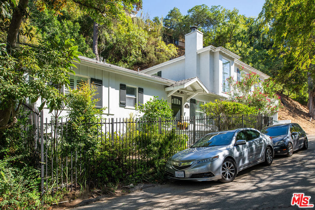 Tucked away on a peaceful and scenic Hollywood Hills Canyon Road, this stunning traditional-style home radiates charm and character. Featuring an open floor plan with vaulted ceilings, a modern kitchen with a breakfast bar, a cozy dining area, a fireplace, hardwood floors, and French doors that lead to a tranquil rear garden with terraced hillside views. The inviting home offers 3 bedrooms, 2 full bathrooms, a den (potential 4th bedroom), and a laundry room. The spacious master suite with soaring ceilings, complete with a luxurious bath with a jetted tub and a private office/flex space, occupies the second floor and opens to a generous wrap-around patio ideal for relaxing in the serene canyon surroundings. Additional highlights include an EV charger, Nest Thermostats, Ring doorbell, new washer/dryer, Culligan saltwater softener, retractable awning off the master, skylights, tankless water heater, storage room, and three private parking spaces - one oversized. Freshly painted, remodeled and located within the Wonderland Avenue Elementary School district, this home is a true oasis!