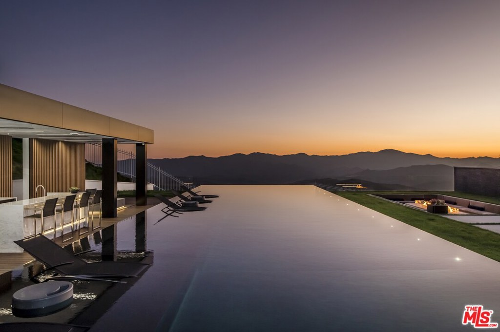 Be the first to occupy this newly constructed one-of-a-kind Calabasas hillside retreat, a striking contemporary-style residence whose French Modern exterior shines in the ultra-exclusive, double-gated celebrity enclave of The Estates at The Oaks. The dwelling was conceived by Michael Palumbo Design whose impeccable craftsmanship boasts opulent finishes and materials of the highest quality. Spanning apx 22,000 sqft of grandeur and emphasizing an outdoor connection, the sprawling sun-splashed residence includes eight en suite bedrooms w/ walk-in closets, a maids quarters with separate entrance, one bedroom guest house and a chic poolside casita. Indulge in all the five-star amenities you could ask fora modern wine room, wellness spa, basketball court, putting green, 10-car garage, an elegant theater and an infinity-edge pool backdropped by breathtaking vistas. Secure your spot in the last of the sought-after view lots in The Estates, and treat yourself to the elegant life you deserve.