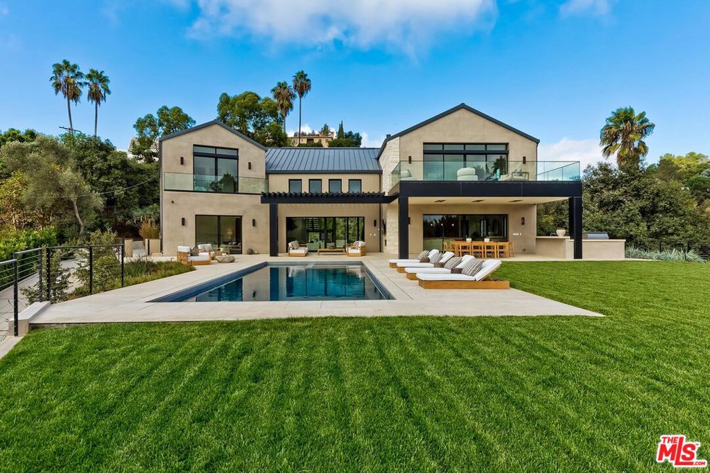 Welcome to 15427 Milldale Drive, a just completed 'Modern Farmhouse' estate blending luxury, style, and comfort. The home was designed and built with strict fire safety in mind. The home uses all steel stud construction and noncombustible exteriors with no eave overhangs, a metal roof and a fully automated fire sprinkler system hooked into a monitored security alarm with city fire hydrant at the bottom of the driveway. Enter through a gated driveway leading to a large motor court, ideal for car collectors. This expansive, approximately 8,000 sq. ft. home sits on a gorgeous 31,240 sq. ft. mostly flat lot, with 6 spacious bedrooms and 7 bathrooms, ensuring privacy and convenience for family and guests. The beautifully landscaped grounds offer stunning canyon views. The interior has, 12-inch-wide Spanish oak floors and soaring vaulted ceilings made from Yukari hardwood create a luxurious atmosphere. Large sliding Fleetwood doors flood the home with natural light, creating an indoor / outdoor living environment. A striking limestone 'spine wall' adds a unique touch of elegance. Smart home technology is integrated throughout offering complete customization of systems for a tailored living experience. The home includes a solar panel system, four-zone HVAC, security cameras, and tankless water heaters to ensure modern convenience. The first floor boasts a 16-foot glass entry with views of the backyard and pool, leading into an open floor plan with a cathedral ceiling. The chef's kitchen is equipped with top-of-the-line appliances, rift-cut oak cabinetry, and marble countertops. Adjacent, the formal dining room comfortably seats 14 or more guests and features stylish built-in buffet cabinets and wine storage. The media room boasts a 98-inch flat screen tv and surround sound making it a retreat to unwind. A main-floor guest suite opens to the pool, while an additional bedroom offers flexibility, ideal as a home office or accommodation for live-in help. Upstairs, the primary bedroom retreat includes a fireplace, living area, and an expansive deck with a fire pit overlooking the backyard. The ensuite spa-like bath features custom stone sinks, a soaking tub, a steam shower, and a dry sauna with treetop views. This 'primary' wing boasts an additional ensuite bedroom that would be ideal as a nursery or upstairs office. Two additional upstairs ensuite bedrooms are located in the opposite wing, one includes a second deck with the same stellar views. Upstairs includes yet another bonus room, perfect to utilize as a playroom, gym, craft room or anything you can imagine. The backyard is a private oasis with two patio areas, one with an outdoor kitchen perfect for alfresco dining, and the other with a poolside fireplace and TV great for entertaining. The large pool includes a lap lane, spa, and an outdoor shower for added convenience. Mature trees and new landscaping enhance the serene canyon views. A three-car garage with electric car hookups completes this stunning property, conveniently located near the Westside, Valley, and Southern California amenities. This is a rare offering!