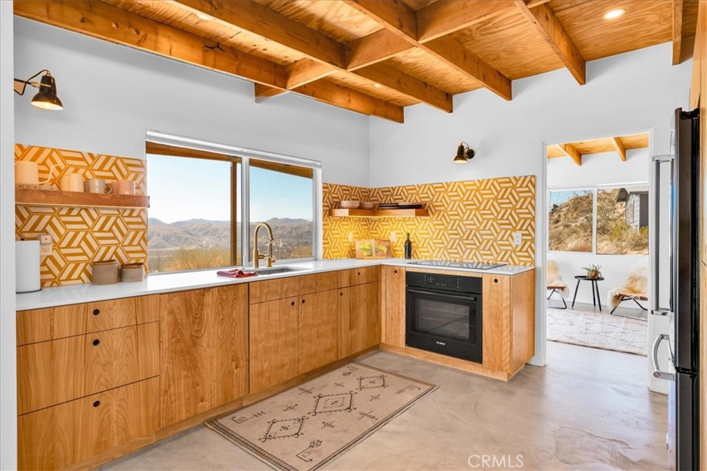 Perched high above the enchanting valley, this charming escape showcases breathtaking panoramic views that stretch across sweeping valley vistas to the majestic peaks of Mt. San Jacinto. Infused with a restored vibe, this home offers an inviting atmosphere perfect for a weekend getaway or a tranquil everyday sanctuary.
Step inside this sun-drenched retreat, where a spacious layout features two well-appointed bedrooms, each designed as a cozy haven to unwind and rejuvenate. The exposed beams throughout amplify the home’s rustic charm, creating a warm and inviting ambiance. The living room serves as the heart of the home, centered around a welcoming wood-burning stove—perfect for those chilly desert nights—as well as a projector for movie nights, allowing for a unique cinematic experience under the stars.
The modern kitchen is a chef's delight, equipped with contemporary Bosch and KitchenAid appliances that cater to your culinary adventures. Further features for the kitchen include: zia tiles, reverse osmosis water filtration (kitchen sink), and Lutron Caseta Smart Lighting. The bathroom is adorned with elegant fixtures, enhances the overall experience of comfort and functionality.
This residence features zoned heating and cooling units, ensuring that every room maintains the perfect temperature year-round. The property also comes with paid solar panels and furnished. A convenient washer and dryer are tucked away inside, providing ease and accessibility for daily chores.
Step out onto the large wooden porch that extends the living space outdoors, ideal for morning coffees, evening gatherings, or simply enjoying the breathtaking views. This outdoor oasis invites relaxation and offers a perfect spot for entertaining guests.
Additionally, the property includes a detached two-car garage, providing ample parking and storage options while keeping your vehicles sheltered from the elements. With plenty of room for an RV or extra vehicles, this is the last house on the road—a one-of-a-kind desert oasis that promises both privacy and adventure.
Embrace a lifestyle where relaxation meets enjoyment in this captivating sanctuary, where every moment can be a cherished memory in your own slice of paradise. All this gorgeous seclusion while still having the convenience of the 10 freeway minutes away, close proximity to both Palm Springs as well as Joshua Tree National Park. Don’t miss the opportunity to make this charming escape your forever home!