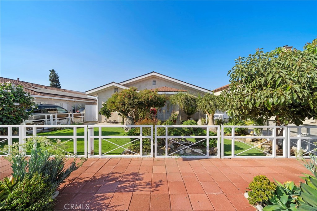 This one-of-a-kind sprawling single-story home has been beautifully expanded to 3,487 square feet of living space, completely remodeled, and is ideally situated on an ultra-rare 12,089 square foot lot with potential to build 1–2 ADUs (city permitting) and/or design the ultimate resort-style backyard with an ADU, located in a desirable neighborhood walking distance to schools and near parks, Disneyland, Knott’s Berry Farm, and Little Saigon; versatile in design, it offers endless options for multigenerational living or the ability to live in part of the home while renting out other rooms, and boasts beautiful curb appeal with fenced lawn, manicured landscaping, and an oversized driveway that easily accommodates 6+ cars with a vinyl sliding fence for potential RV parking; inside, the home showcases 4 remodeled bathrooms, 4–7 bedrooms (some classified as den, study, or exercise rooms), tile and wood laminate flooring, recessed lighting, central A/C system, crown molding, dual pane windows and sliders, new cabinetry, and raised panel interior doors; the double beveled-glass entry doors open to a formal living room with built-in décor niches and flow to a completely remodeled chef’s kitchen with quartz countertops, subway tile backsplash, breakfast bar with pendant lights, custom white shaker cabinetry, stainless farmhouse sink, gas range with vent hood, and dishwasher, open to a dining room with built-in hutch, buffet counter, and wine storage; this highly functional layout also includes 2 family rooms and 2 primary suites—perfect for multigenerational living with separate spaces—one suite featuring wainscoting, mirrored closets, and a luxurious bathroom with granite vanity, soaking tub, and walk-in shower; the expansive backyard offers a large covered patio, tile decking, block wall fencing, and abundant room for future expansion. There is also a spacious inside laundry room and this home has direct access to a finished 2-car garage with tile flooring. Truly a rare find, this remarkable home combines size, style, and versatility on a massive lot, offering endless opportunities for comfortable living, entertaining, and future growth.