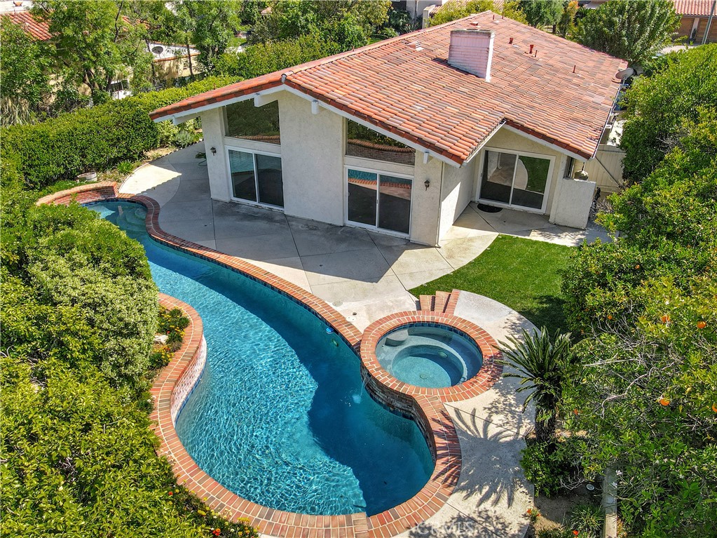 Welcome to this exquisite 3-bedroom, 3-bathroom single-story sanctuary nestled in the Calabasas Park neighborhood of Calabasas! Tucked away on a serene cul-de-sac, this home radiates refined sophistication and warmth. A grand entryway invites you into a luminous, open-concept living space with soaring vaulted ceilings, gleaming stone floors, and a cozy fireplace. The chef’s kitchen is a culinary masterpiece, featuring a spacious center island, custom-crafted cabinetry, and built-in shelving for media and storage. The primary suite offers a private retreat with a fireplace, expansive walk-in closet, additional wardrobe space, and an ensuite bathroom with dual vanities and tiled shower. On the opposite wing, two spacious bedrooms share a sleek bathroom with a modern vanity. The front yard, enveloped by lush greenery and towering trees, ensures tranquil privacy, while the backyard is a stunning oasis with a sparkling pool, cascading spa, verdant lawn, and generous space for entertaining. Additional upgrades include a newer roof, newer water heater, and dual pane windows throughout. Just moments from the exclusive Calabasas Lake, vibrant Old Town Farmer’s Market, and The Commons for premier shopping and dining. Discover this Calabasas gem today!