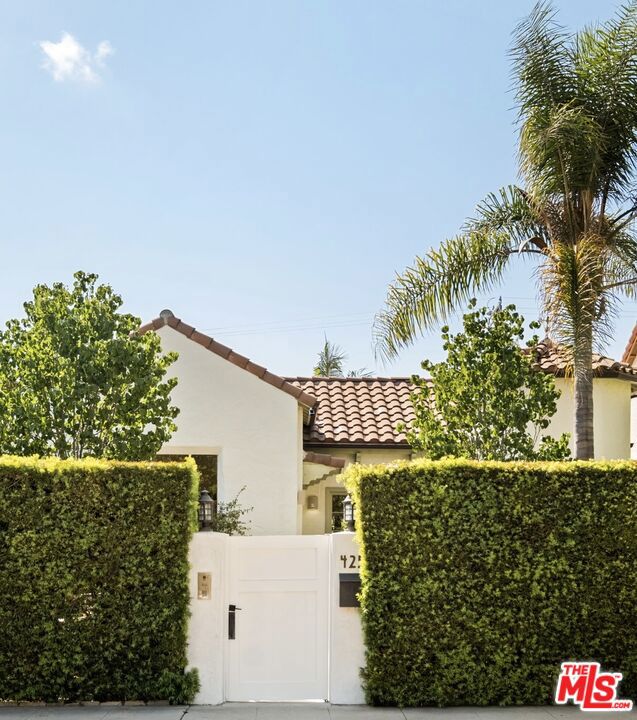 Welcome to 425 N Croft Avenue, a stunning Spanish bungalow that effortlessly blends classic charm with thoughtful updates. This meticulously maintained 4-bedroom, 3-bath home is designed for both comfortable everyday living and elegant entertaining. From the moment you arrive, the gated and hedged property offers complete privacy and a serene retreat in one of the city's most desirable neighborhoods.Step inside to discover an abundance of natural light pouring through expansive windows, highlighting the home's high ceilings, exposed beams, and original wood floors. The living spaces are warm and inviting, centered around a wood-burning fireplace that adds character and charm to the open layout. The attention to detail is evident throughout, with thoughtfully designed spaces that combine style and functionality.The primary bedroom is a true sanctuary, featuring an en-suite bathroom and dual custom-built walk-in closets, and elegant French doors that open directly to the backyard, creating a seamless indoor-outdoor flow. A second bedroom also includes an en-suite bathroom as well as French doors leading to a side patio that connects to the backyard, providing a private retreat for guests. The remaining two bedrooms share a beautifully appointed bathroom, providing ample space and comfort for family or guests. An additional flexible space, formerly a garage, has been beautifully converted into a recreation room, perfect for a home office, gym, or media room.The heart of the home is the newly designed, high-end eat-in kitchen, complete with a custom leather banquette, extensive storage, and top-of-the-line appliances, including Thermador, Sub-Zero, and Bosch. This space is ideal for culinary enthusiasts and makes hosting gatherings effortless and stylish. Tile bathrooms throughout complement the home's sophisticated design, adding a touch of elegance while maintaining the classic Spanish feel.Step outside to enjoy the private backyard, an ideal setting for relaxing or entertaining. The outdoor space is as inviting as the interior, offering a tranquil environment that feels miles away from the hustle and bustle. Located in a highly sought-after area, the home offers easy access to premier shopping, dining, and entertainment, while still maintaining a peaceful, residential feel. With its perfect combination of classic Spanish charm, thoughtful updates, and exceptional location, this home presents a rare opportunity to experience the best of Los Angeles living.