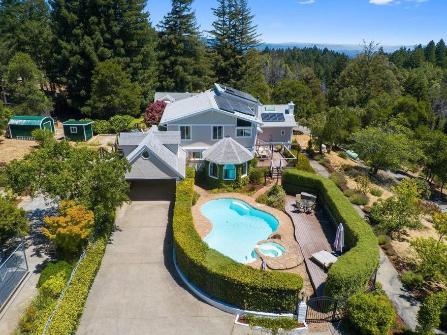 Discover Stillpoint, where a former Zen retreat center, soaked in sunlight, becomes your own everyday escape. Set behind a gated entry, this one of a kind 2.5 acre estate is a private haven of peace and beauty. This versatile property offers several structures and residences.The 4BR/3.5BA 3,819 square foot main home is full of natural light. The kitchen and primary bathroom are updated with timeless finishes. The home feels warm and welcoming with hardwood/ bamboo floors, and a wood stove. Soak up the sun on one of several expansive decks. A permitted 2BR/1BA 902 square foot ADU sits above the 3-car garage, complemented by a detached 330 square foot studio guest house and a flex space/office with half bath off the primary suite balcony. Enjoy a private saltwater pool and spa with solar and propane heating, a full-home backup generator, 14kW owned solar, and high-speed internet. Landscaped grounds include gardens, orchards, patios, and trail access to Fall Creek State Park. With an RV hookup, potential pickleball court, fenced perimeter, and multiple living spaces, Stillpoint is a rare blend of functionality and restorative calm, where the name truly reflects the experience.