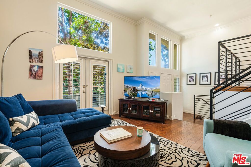This rare townhome in the desirable Crescent Walk building of Playa Vista features its own private entrance, a two-car garage with direct access to the home, and an ideal layout. Inside, soaring 18-foot ceilings and expansive windows fill the home with natural light and treetop views. Rich wood flooring flows throughout the home, bringing a sense of warmth and continuity. The beautifully updated kitchen features marble countertops, a walnut bar, modern cabinetry, and stainless steel appliances. It overlooks the living room and front-facing balcony with peaceful treetop views- perfect for entertaining with great light and privacy. The dining area connects the space with style and functionality. The spacious layout includes two large bedrooms, both of which open to a rear-facing patio that overlooks the lovely courtyard. The primary suite features a beautiful ensuite bathroom with dual vanities and a stand-up shower. The second bedroom has its own full bath just outside, making it ideal for guests or a home office. A private storage room spanning approximately 325 square feet, almost the full length of the home, adds incredible bonus space. Crescent Walk has its own fitness center and a serene courtyard with seating areas. This prime location is just moments from the Playa Vista Library, the highly sought-after Playa Vista Elementary School, and the resort-style amenities at both The Resort and the Centerpointe Club. Enjoy the vibrant Playa Vista lifestyle with Runway's shops, dining, Whole Foods, and entertainment all close by.