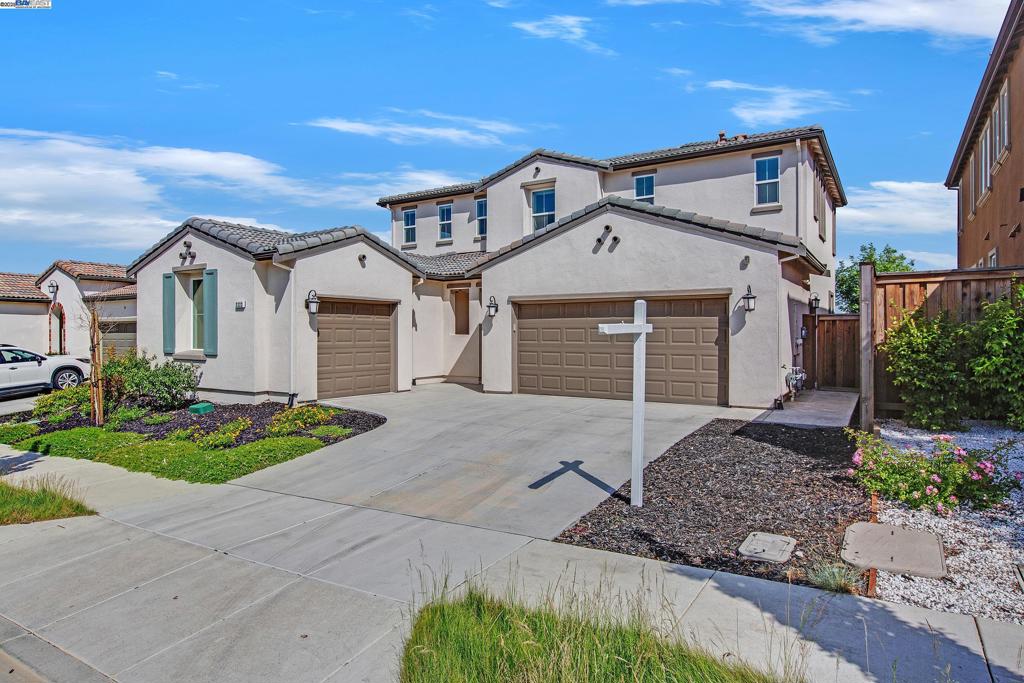 Experience exceptional living in the Tracy Hills community w/ 3,311 sf home, situated on a 5,760 sf lot & 3-Car Garage adjacent to the Clubhouse & Corral Hollow Elementary School. Built by Shea Homes in 2021, this residence features over 200k in owner/builder upgrades, blending modern luxury with everyday comfort. The floorplan offers 4 spacious bedrooms & 3.5 baths, including a convenient downstairs junior suite; A glass-enclosed office-ideal for working from home. The inviting living & dining spaces seamlessly connect to a fully upgraded kitchen, highlighted by a dramatic waterfall island, premium soft-close cabinetry, stainless steel appliances, and a 5-burner cooktop. Premium electric roller blinds in the living, dining & master bedroom, rich wooden flooring downstairs, and plush carpeting upstairs add elegance throughout. Expansive Mastersuite, complete with a walk-in closet, dual vanities, a soaking tub & a separate shower. All bathrooms are fully upgraded. Enjoy smart home features a camera doorbell, Amazon Echo, Eero & a smart thermostat. Both garages offer premium epoxy flooring. Beautifully landscaped, low-maintenance backyard w/ artificial turf, stamped concrete, built-in seating, and a tranquil water fountain-perfect for entertaining guests.