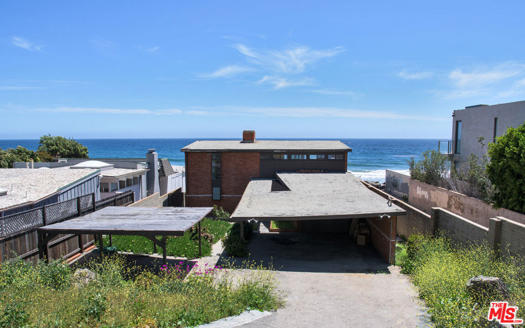 An exceptional opportunity on the prestigious and highly sought-after Broad Beach Road. This classic mid-century home, built in 1953, offers breathtaking ocean views and direct access to one of Malibu's most iconic stretches of coastline. The main level welcomes you with exposed brick, rustic hardwood floors, soaring beamed ceilings, and expansive floor-to-ceiling windows that bathe the interior in natural light. A wood-burning fireplace adds warmth and charm, while the lush backyard, adorned with mature succulents, invites you to unwind in a serene coastal setting.Upstairs, the primary bedroom is complemented by a secondary living area featuring another wood-burning fireplace and opening onto a generous deck with sweeping views of the Pacific. With approximately 50 feet of beach frontage and nearly 2,000 square feet of living space, this property presents the perfect canvas to create your dream Malibu retreat.