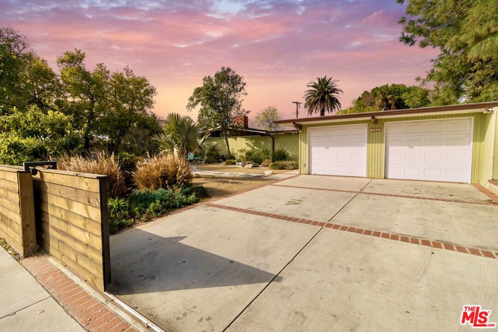 Palm Springs-Style Oasis in Northridge! Step into your own mid-century modern retreat, where lush landscaping, vibrant outdoor living spaces, and a heated saltwater pool create the perfect Palm Springs-inspired escape. Designed for both relaxation and entertaining, this stylish 4-bedroom, 2-bathroom home is a rare gem. The home has modern upgrades ensuring comfort and efficiency, including a new roof, updated electrical system, advanced security system with cameras. Plus, paid-off solar panels help keep energy costs low. Conveniently located near top-rated schools including the Balboa Gifted/High-Ability Magnet Elementary School, and less than 20 miles from Hollywood. Inside, the bright and airy living room features an original fireplace, sleek polished concrete floors, and sliding glass doors that seamlessly connect indoor and outdoor spaces. The kitchen blends classic design with modern updates, including new countertops, a stylish sink, and dishwasher. Down the hall, three spacious bedrooms offer ample storage, each have large windows outfitted with motorized shades. The primary suite is a cozy retreat with mirrored closet doors, and a private bathroom. Also included is a versatile bonus room - once used for orchid cultivation - now can be used as the perfect space for a home office, workout room, and much more. The backyard is a true desert-inspired oasis, with lush landscaping and multiple lounging areas. A detached storage shed provides extra flexibility, whether used for extra storage or as a studio or workshop space. Showings by appointment only.