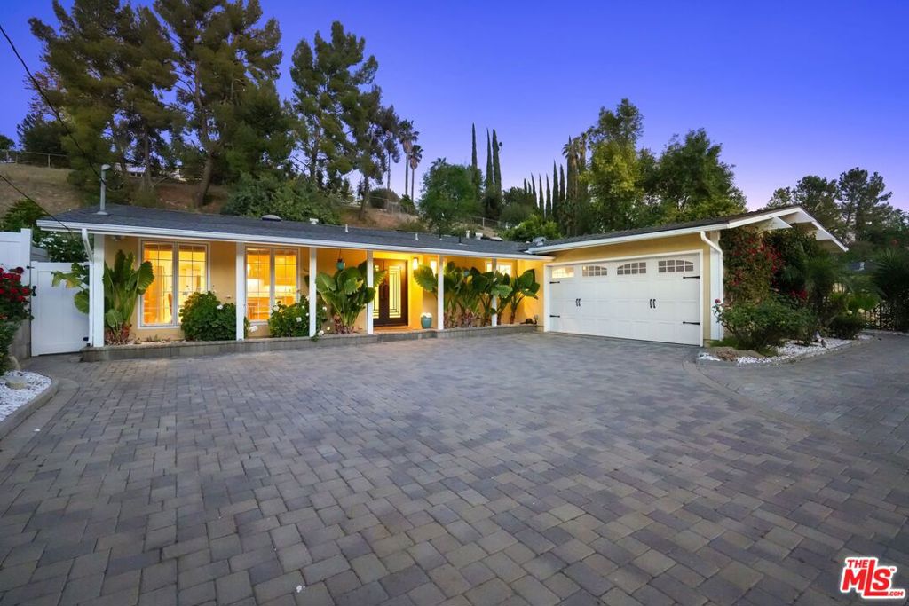 Sunny Garden Escape. Surrounded by greenery, fragrant rose bushes and mature fruit trees, your lush garden hideaway awaits on a quiet street in West Hills. Elegant finishes start with the driveway pavers and continue throughout this bright and cheery home. The custom double-door entry leads to thoughtful upgrades and a generous flow. The spacious kitchen with granite counters, stainless steel appliances and massive center island is ready to serve a sizable feast or an intimate dinner. Walls of cabinets store everything you need to welcome friends and family. A fireplace draws warmth into the family room and solar tubes illuminate natural light throughout an open floor plan. Wide sliding doors lead from the open floor plan living and dining rooms to an entertainer's dream back yard complete with a putting green, gas fire pit, sparkling waterfall, and built-in kitchen with BBQ, side burners, drawers and sink. An abundant lemon tree anchors the lower yard and sweeping stairs lead to a perfect landing for an additional garden space or orchard with peaceful sunset views. The main bedroom includes an oversized walk-in closet and connects to a full bath and additional bedroom with walk-in cedar-lined closet. Another bedroom invites with an ensuite bath, custom tile work and soothing rainfall shower panel. The attached two-car garage features climate control and built-in shelving perfect for your at-home office, creative workshop or vintage cars. Hardwood floors, recessed lighting, remodeled powder room, newly installed solar panels, Nest thermostat and Carrier high efficiency air filtration system round out the home's beauty and efficiency. Ring doorbell and ADT alarm system complete the home's security. Two large sheds mean your driveway is free of clutter. The driveway has plenty of room for an RV. Fruit trees and bright roses and geraniums create a little paradise. Entertain a crowd or simply enjoy restful nights at home surrounded by the charm that this enchanting home has to offer. Park trails are close by. The Calabasas Farmers Market serves up organic produce in nearby Old Town Calabasas. There is fantastic shopping in several area malls and a burgeoning restaurant scene. Everything you need is here, peace and tranquility, and access to all the world has to offer.