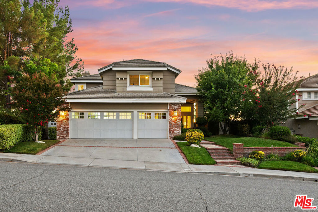 One of the most private lots in all of Northbridge, this stunning Warmington-built home offers jaw-dropping panoramic views with only one neighboring home no home to the west and none across the street. From sunrise to golden sunset, you'll enjoy sweeping vistas of hills, Magic Mountain in the distance, and starry skies at night all from your own quiet retreat. It also overlooks a beautiful public park and sits adjacent to a network of scenic walking and biking paseos that connect you to the very best of the neighborhood. This spacious 2,462 sq ft residence offers 3 bedrooms, 3 bathrooms, plus a versatile office/study. Inside, high vaulted ceilings and sun-filled living spaces set the tone. Plantation shutters, hardwood floors, and an open-concept layout make the home warm and inviting. The upgraded chef's kitchen features Viking, Bosch, and LG appliances, granite counters, and a breakfast bar that flows into the family room with a cozy fireplace. French doors open to multiple outdoor seating areas, perfect for enjoying those one-of-a-kind views and evening sunsets. Upstairs, the expansive primary suite captures the panorama with automatic blackout shades, a large walk-in closet, and spa-like bath with soaking tub and separate shower. Two additional bedrooms share a generous dual-sink bath, and the added office space provides a quiet spot to work or study. Owned solar panels add modern efficiency. The community is equally special: tree-lined paseos, three swimming pools, tennis and basketball courts, playgrounds, and the award-winning Helmers Elementary School just minutes away. With a 3-car garage and low HOA dues, no Mello Roos, this home is the rare combination of location, privacy, and lifestyle. From family gatherings to peaceful evenings with panoramic sunsets, this home truly sits in a world of its own.
