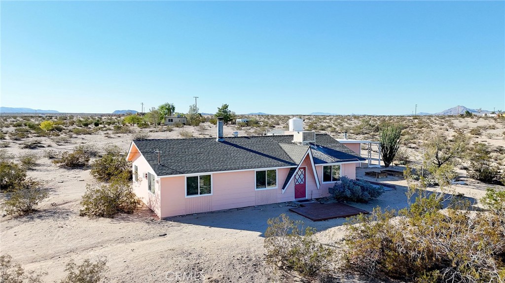 Welcome to this beautiful 4+1 desert oasis where tranquility meets adventure! Nestled in the heart of Joshua Tree, this stunning property offers the perfect blend of privacy and convenience, just minutes from the iconic Joshua Tree National Park. This spacious home sits on a generous 5 acres lot, providing ample room for outdoor entertaining, gardening, or simply soaking in the serene desert landscape. The interior boasts modern finishes, an open-concept living area, and large windows that flood the space with natural light, a new 8' × 12' entry deck opens into a bright open-plan living room and kitchen anchored by a brick fireplace, with a large sliding-glass door to the patio and garden for seamless indoor-outdoor living, year-round comfort comes from central heating plus two central cooling systems—a high-efficiency ducted heat-pump AC for peak summer heat, and a whole-house ducted evaporative cooler delivering fresh, moist, economical airflow during the rest of the year, recent upgrades include new double-pane windows, remodeled kitchen and bath, new bedroom addition, fresh interior and exterior paint, upgraded wraparound porch, native desert landscaping, outdoor hot-water soaking tub, two irrigated garden beds, and several storage sheds. Foundation and roofline are in place for an easy future second-bathroom addition off the primary suite, with an inexpensive, trusted contractor ready to do the project. Whether you’re seeking a peaceful getaway, a family home, or a lucrative short-term rental, this property checks all the boxes. Nearby, you’ll find popular local spots like Joshua Tree Coffee Company, Crossroads Café, and the eclectic shops of downtown Joshua Tree. Enjoy easy access to hiking trails, art galleries, and vibrant community events. Don’t miss your chance to own a slice of paradise in one of California’s most sought-after destinations. Schedule your private tour today and experience the magic of Joshua Tree living!
