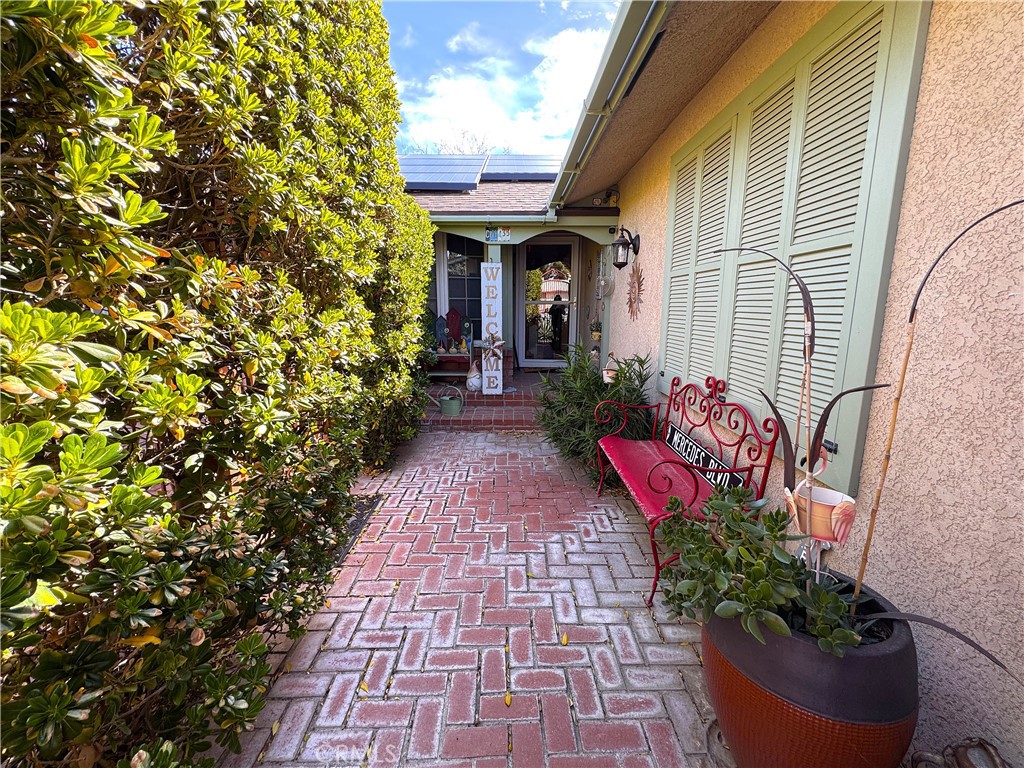 VIRTUALLY NO ELECTRCI BILL WITH PAID OFF SOALR!!!Step into this stunning home, offering nearly 2,000 sq. ft. of living space with a beautifully designed layout, featuring 4 spacious bedrooms, including 2 primary suites with large closets—one with custom interior design. One of the primary bedrooms serves as a delightful guest room, designed for handicap accessibility, with its own exclusive entrance and a breezeway connecting it to the main part of the home. The main primary suite has French doors leading to the front garden, offering a serene and private escape. The home boasts 3 bathrooms, each with unique features such as a designer sink, a walk-in tiled shower, and elegant vanity tops. The formal living room impresses with a huge antique English mantel above a cozy wood-burning fireplace, complemented by a dining area ideal for entertaining. French doors in both the living room and dining area open to the beautiful backyard, allowing for seamless indoor-outdoor living. One of the 4 bedrooms is currently used as a library, featuring custom-built bookcases and shelves. The spacious kitchen is a chef’s dream, with a large garden window, a breakfast bar, a cozy eating area, granite countertops, a farmhouse sink, a five-burner stovetop range, custom cabinets with pullouts, and top-of-the-line stainless steel appliances. The kitchen opens to a charming area with a bay window, creating a perfect space to relax. For those working from home, the office/study with built-in desk, cabinets, and bookshelves offers the ideal workspace. Throughout the entire home, premium wood flooring adds warmth and elegance, except in the kitchen. The laundry room is a hidden gem, featuring a built-in ironing board, sewing center, large pantry, and exterior Dutch door providing ample storage. The two-car garage features a gated entrance for added security and privacy. The front yard boasts a charming garden with brick ground covering, while the back and side yards are fenced with pecky cedar, offering easy-care, desert-friendly landscaping with drought-tolerant plants. A large, covered patio allows you to enjoy the serene surroundings, complete with roses and mature trees. Best of all, this home comes with an impressive solar system (33 panels), fully paid off, ensuring very little electricity cost for the new owner. This rare, beautifully designed home offers exceptional value by blending style, comfort, and function. Experience all the charm and beauty it has to offer!